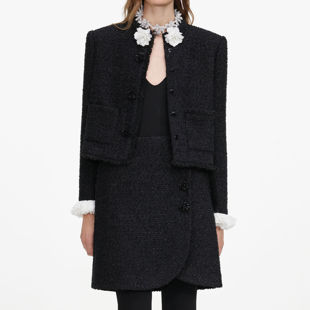 A close up of a woman wearing the Black Boucle Flower Jacket