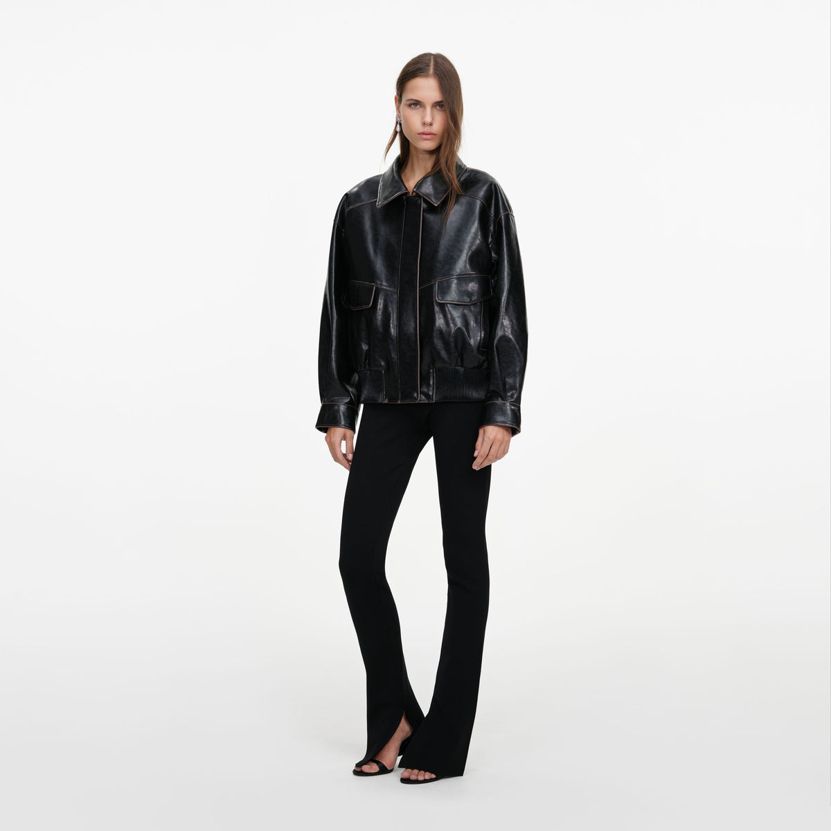 Side view of a woman wearing the Black Oversized Faux Leather Jacket