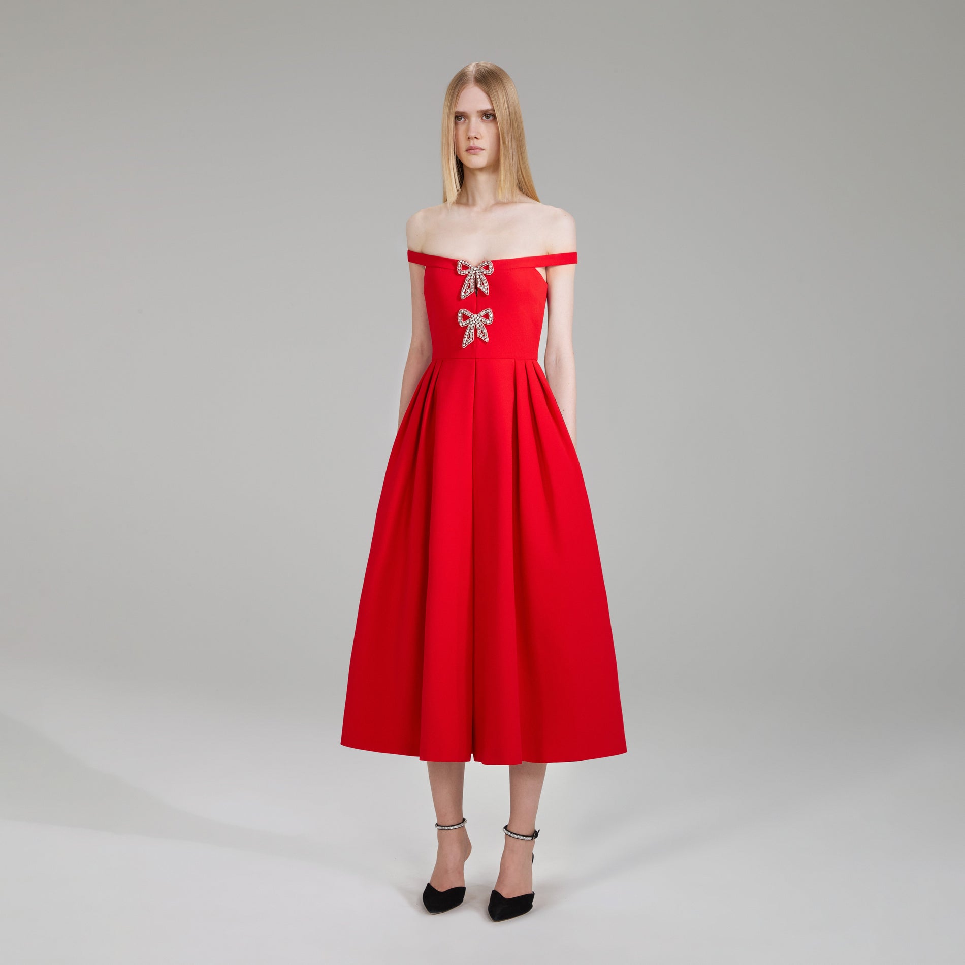 A woman wearing the Red Crepe Bow Midi Dress