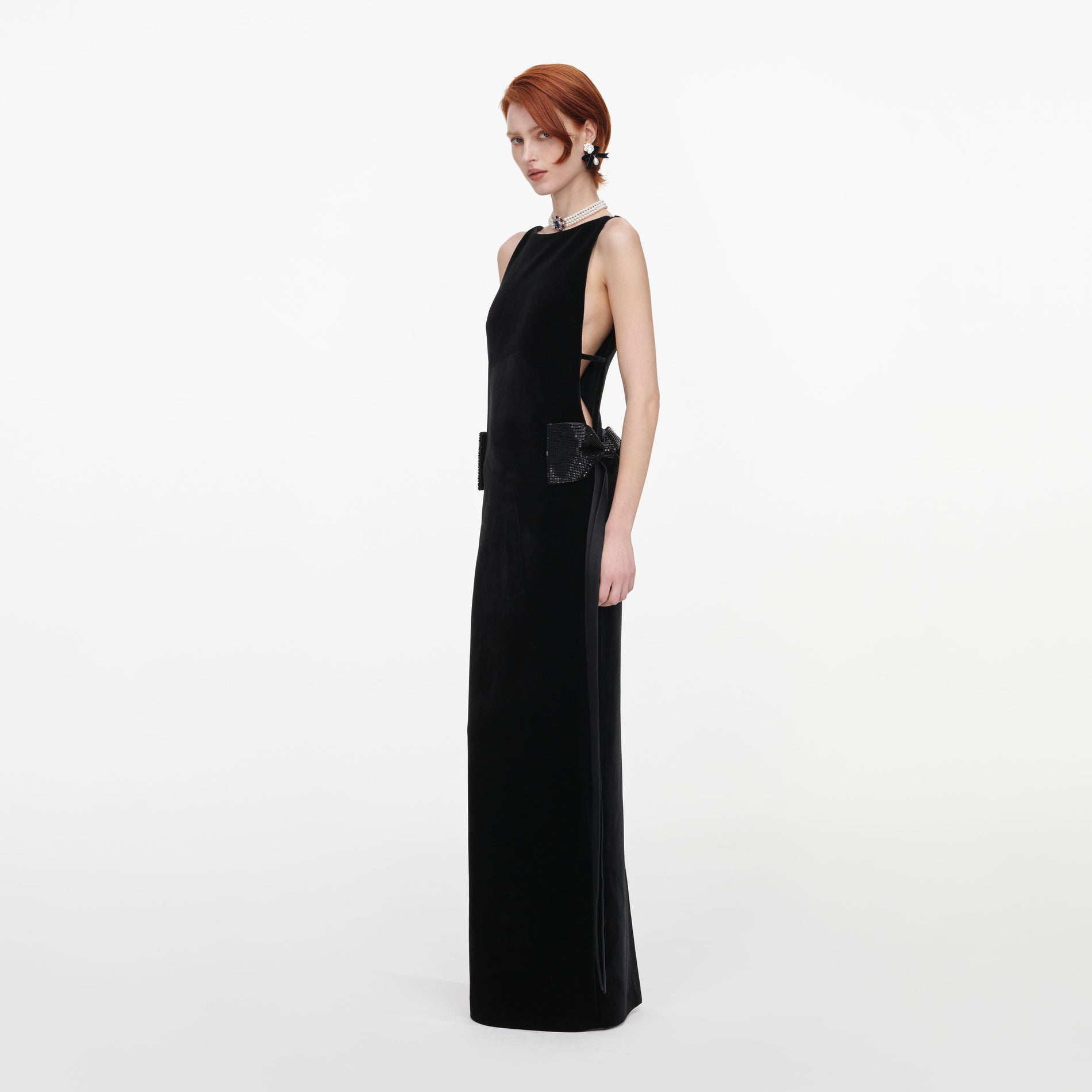 Side view of a woman wearing the Black Velvet Bow Sides Maxi Dress