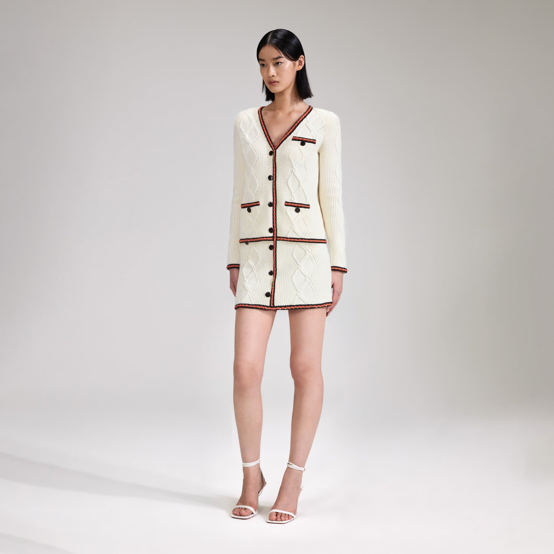 A woman wearing the Cream Cable Knit Cardigan