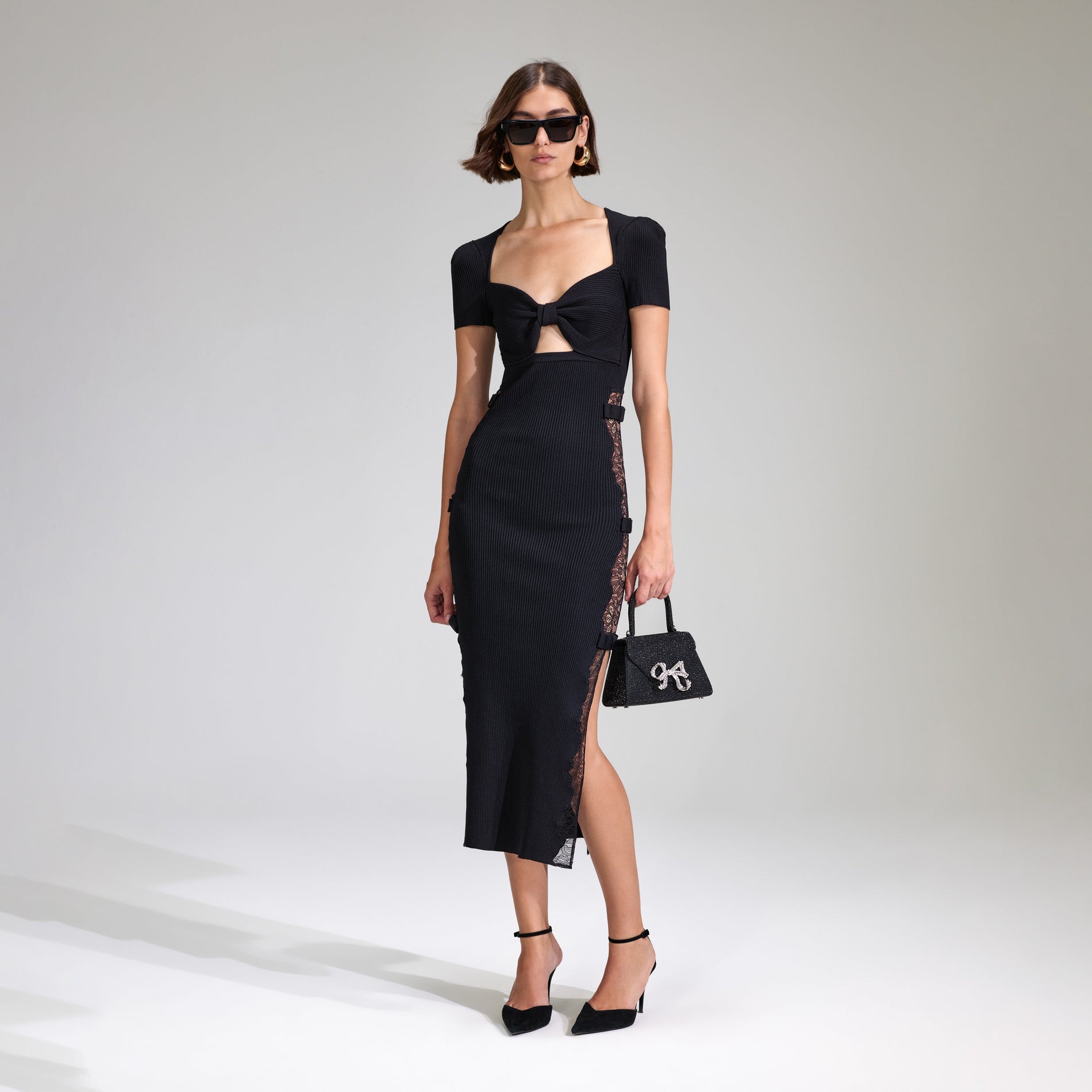 A woman wearing the Black Viscose Knitted Midi Dress