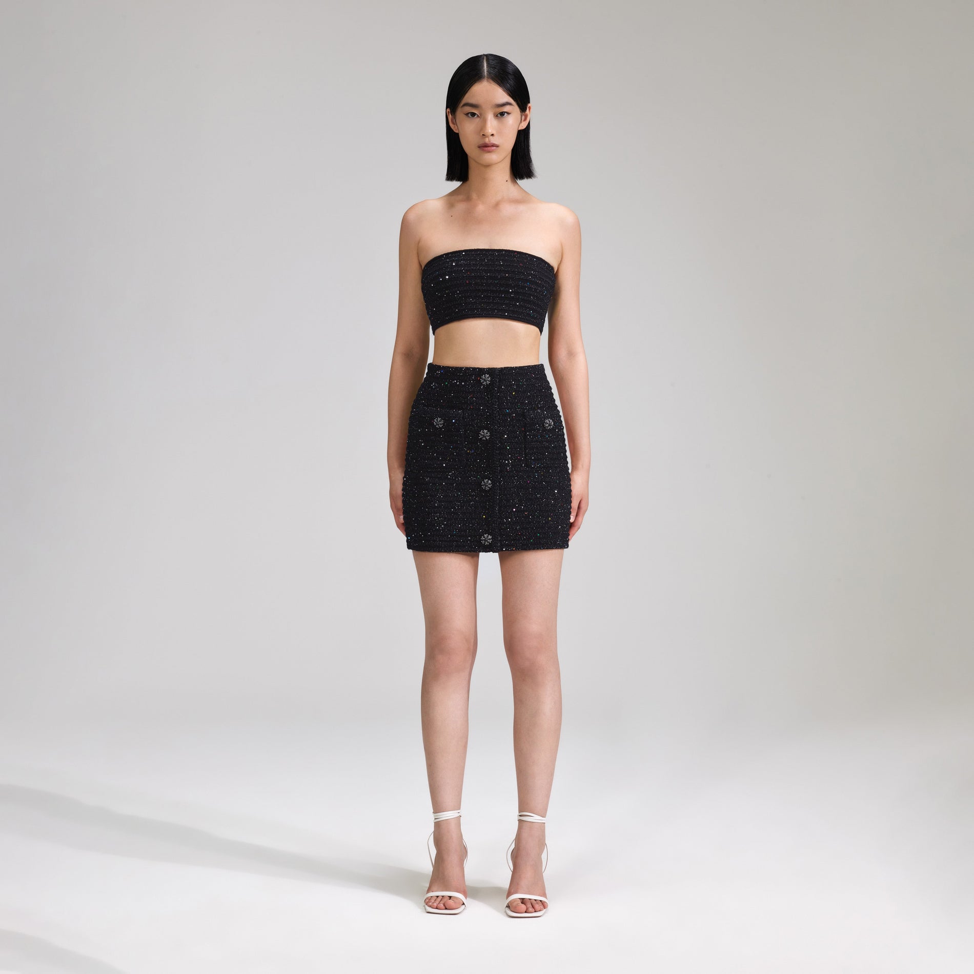 A woman wearing the Black Sequin Knit Bandeau Top