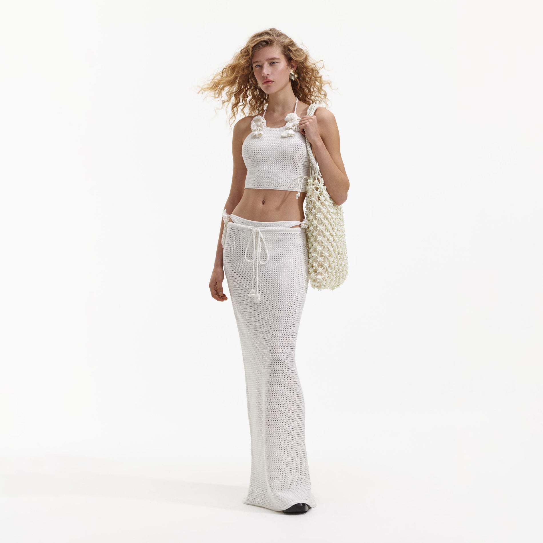 Side view of a woman wearing the White Crochet Maxi Skirt