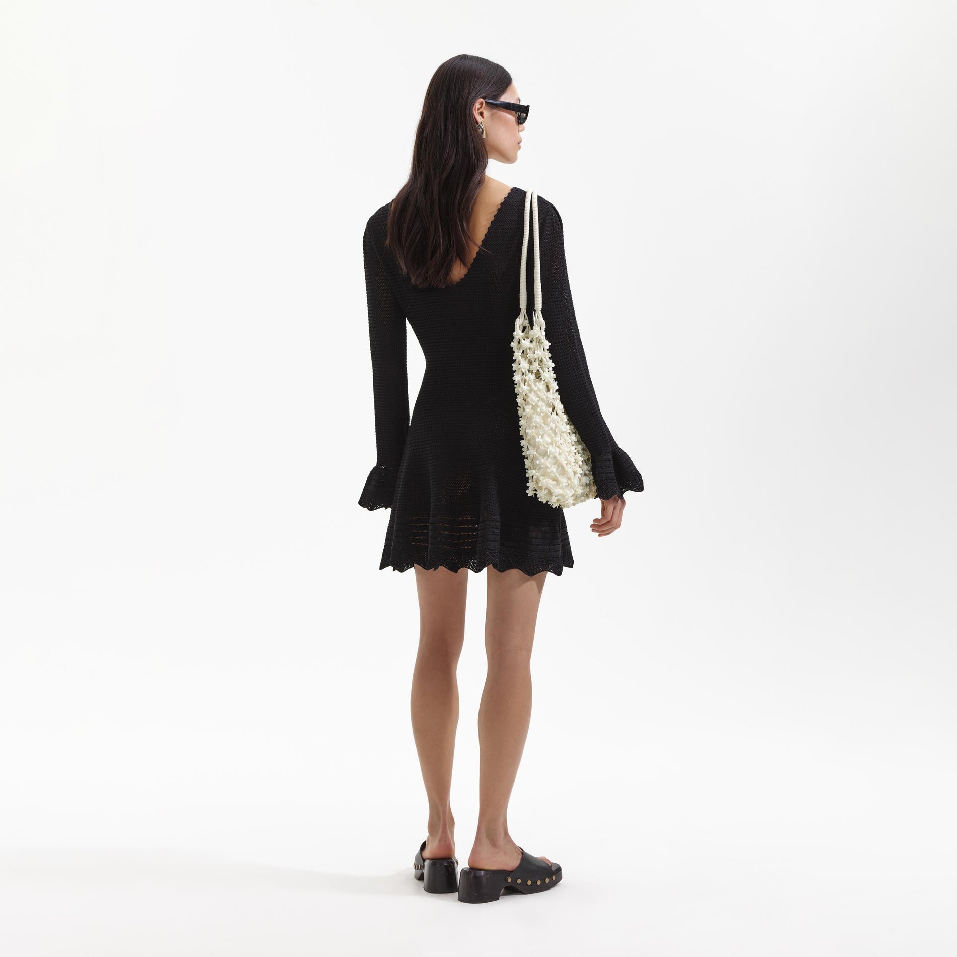 Back view of a woman wearing the Black Crochet Mini Dress