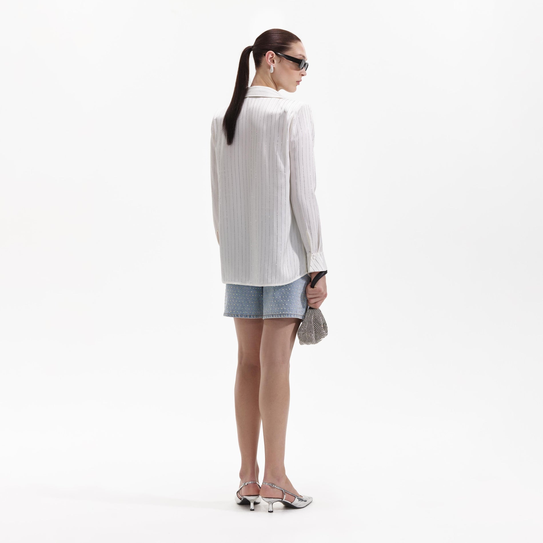 Back view of a woman wearing the White Rhinestone Stripe Shirt