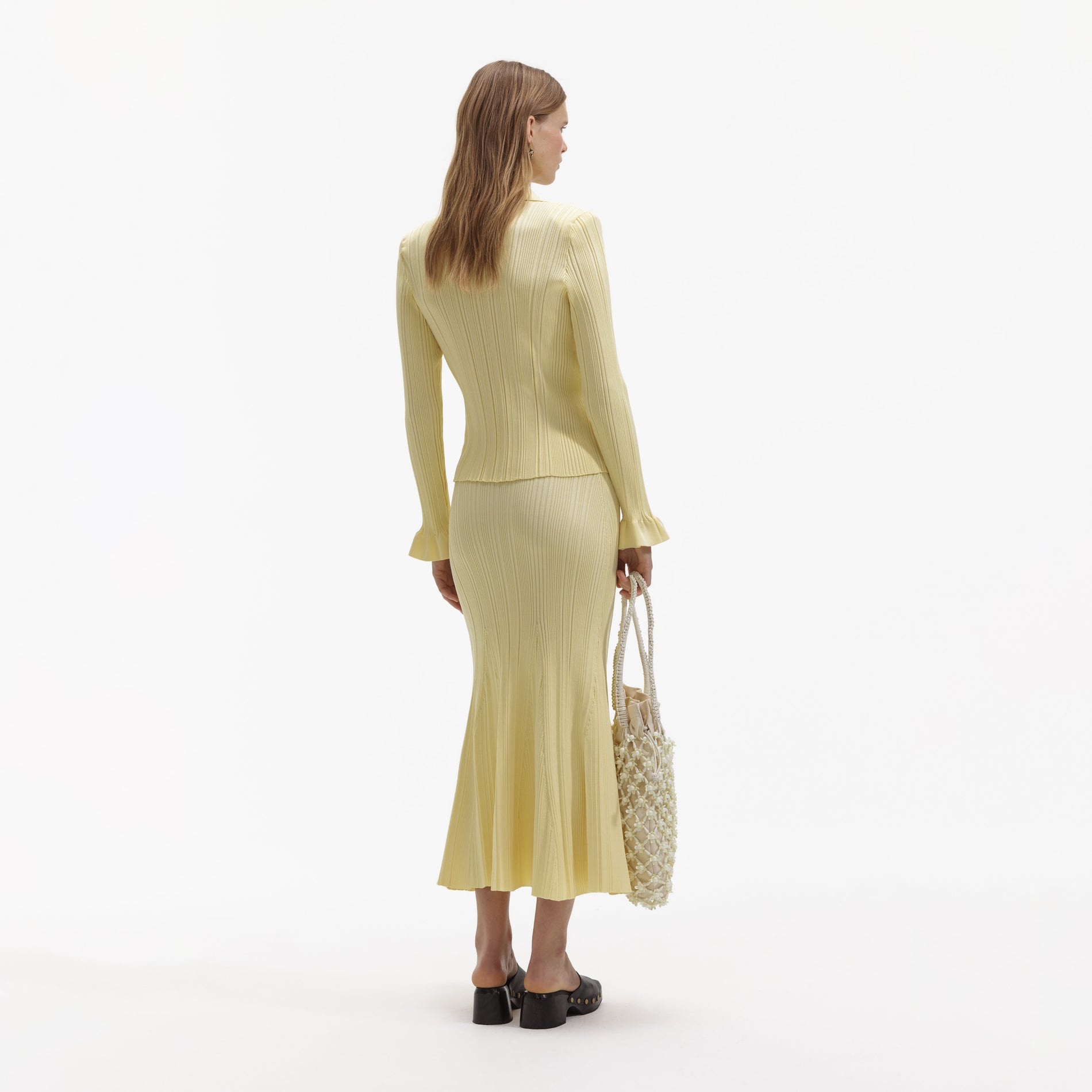 Back view of a woman wearing the Yellow Ribbed Viscose Knit Skirt