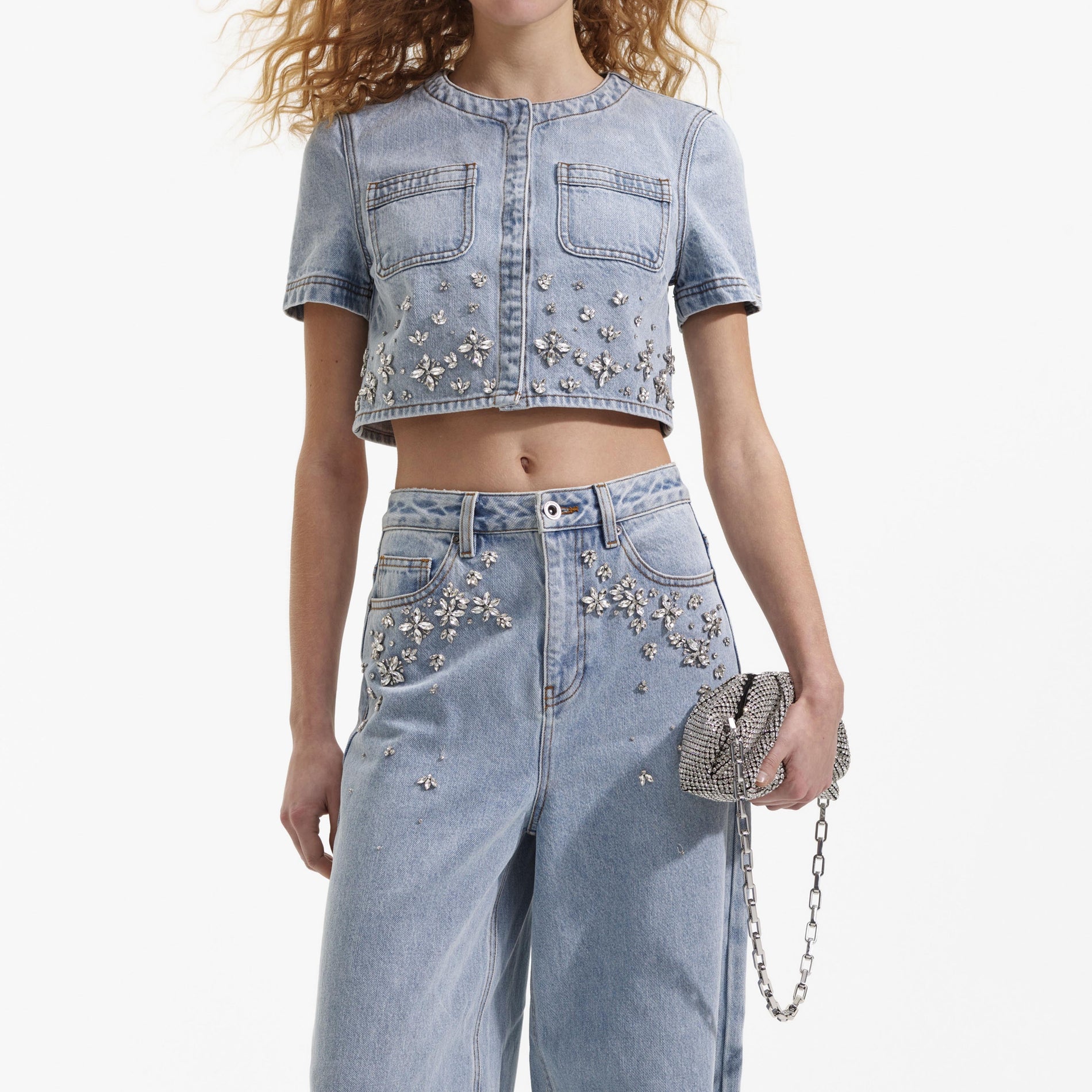 A close up of a woman wearing the Blue Embellished Denim Top