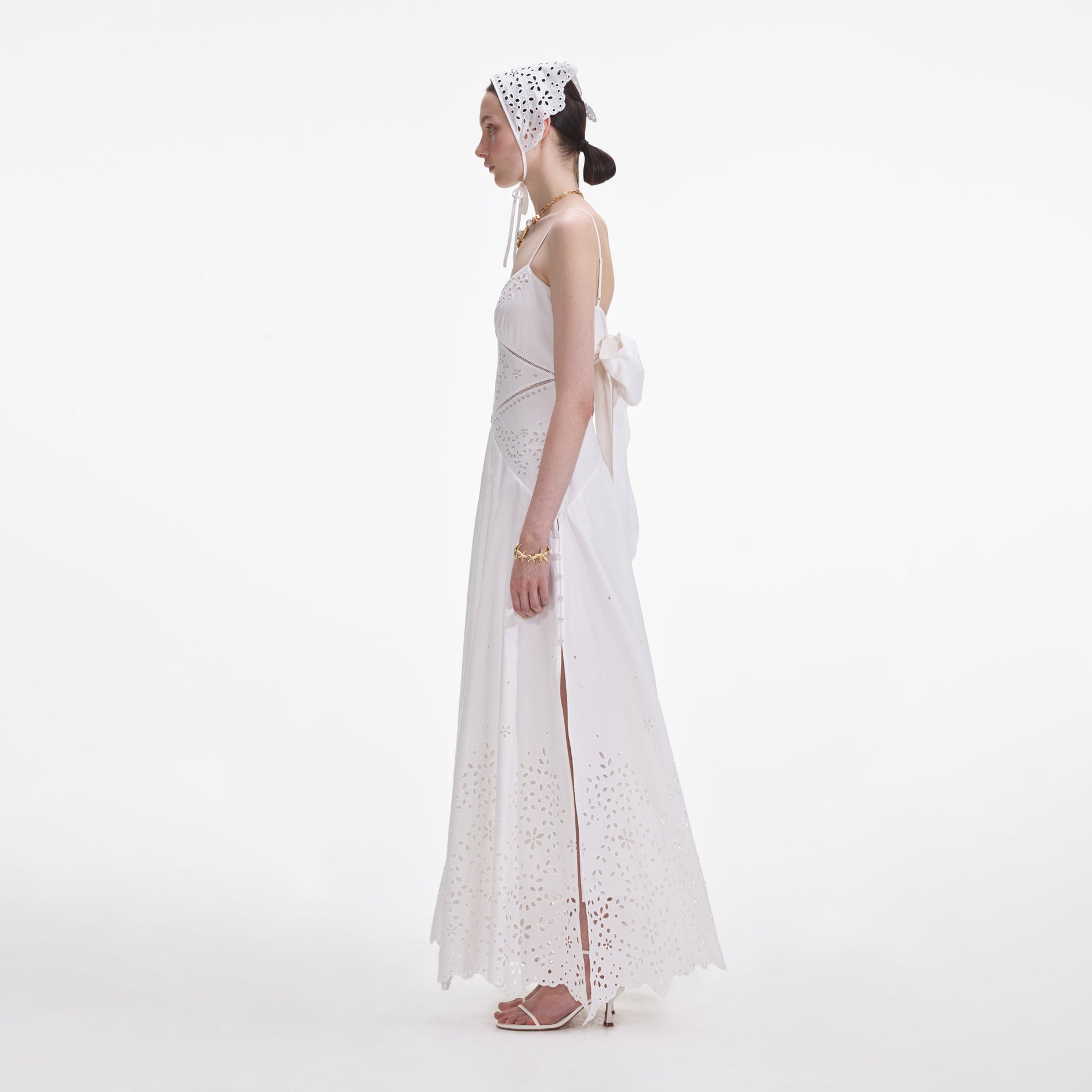 Side view of a woman wearing the White Cotton Embroidered Maxi Dress