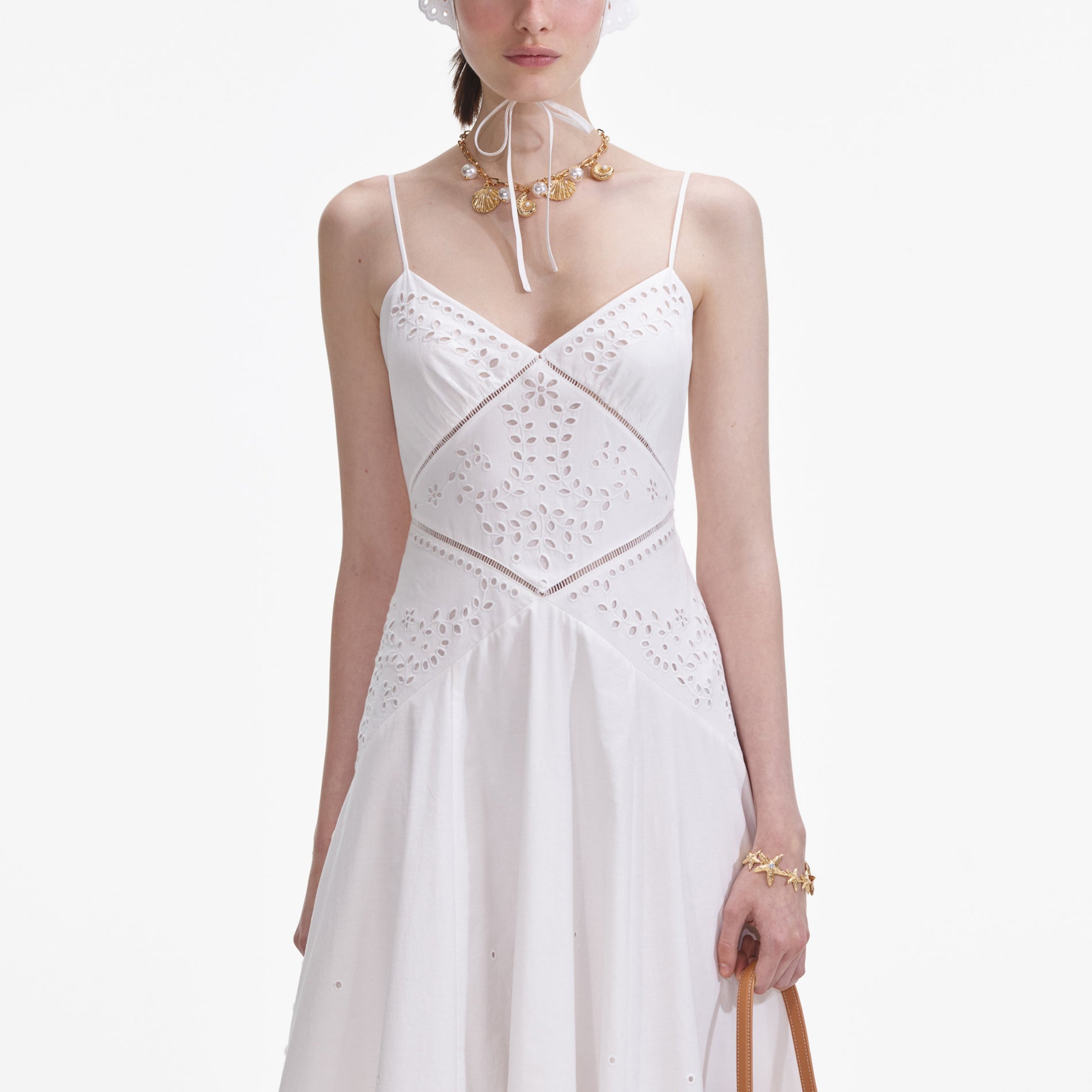 A close up of a woman wearing the White Cotton Embroidered Maxi Dress