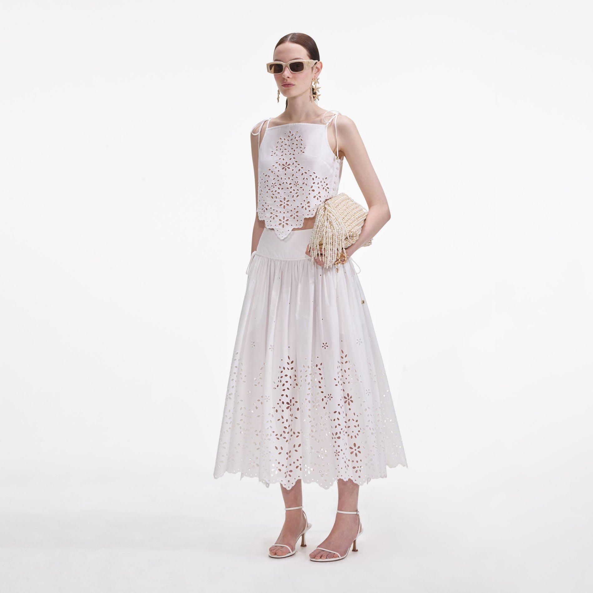 Side view of a woman wearing the White Cotton Embroidered Midi Skirt