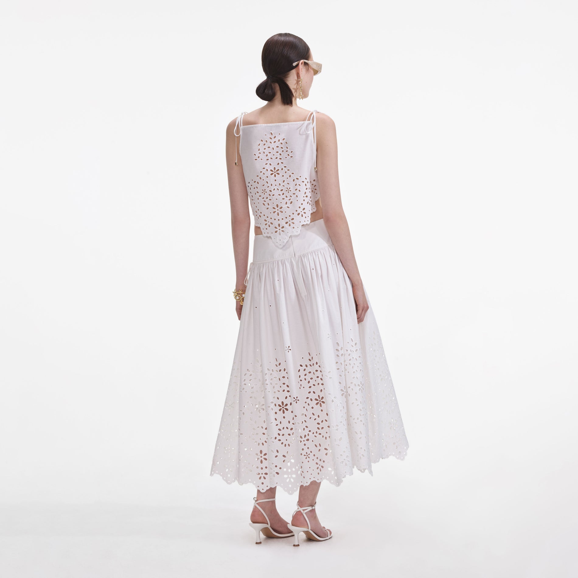 Back view of a woman wearing the White Cotton Embroidered Midi Skirt