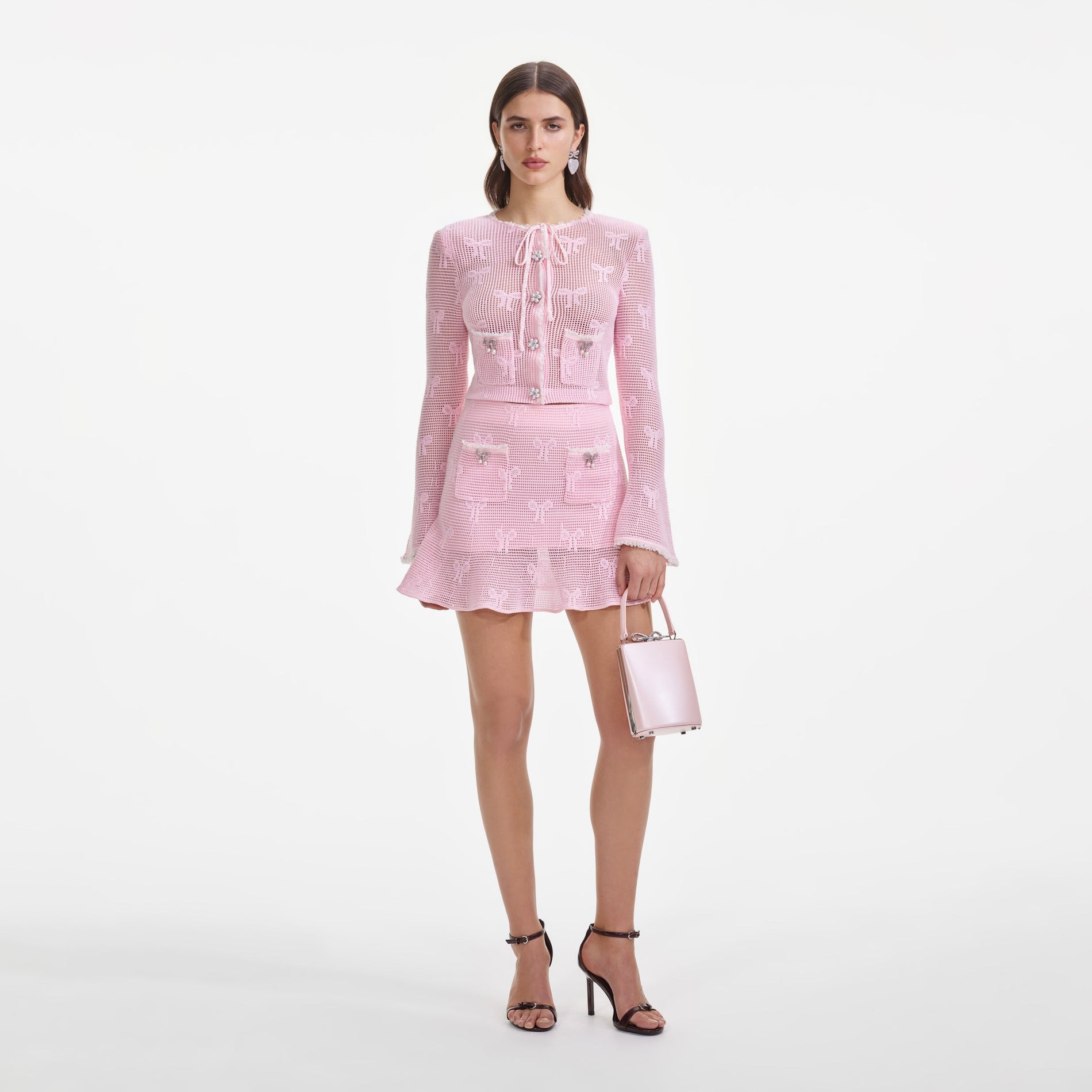 Front view of a woman wearing the Pink Bow Crochet Cardigan