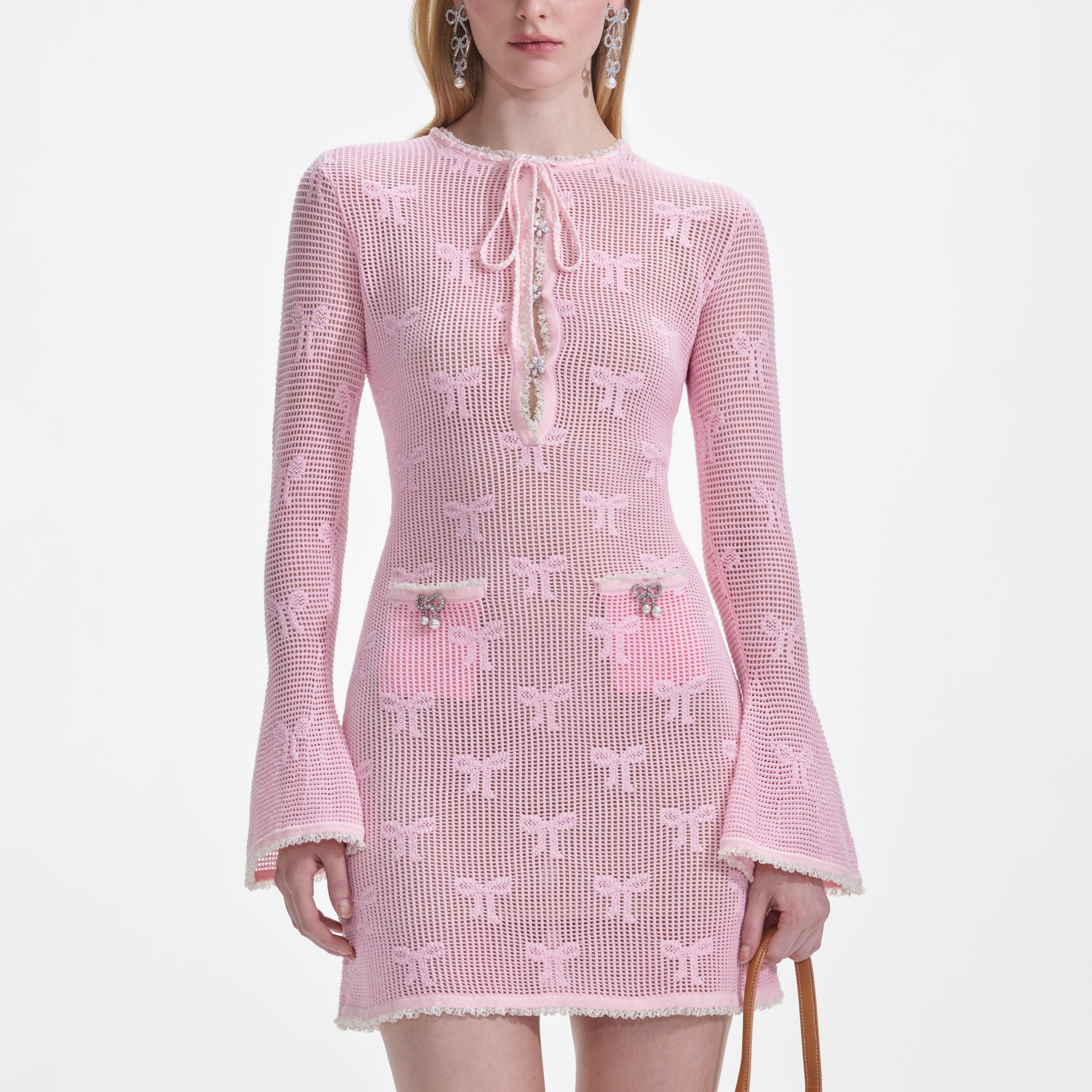 A close up of a woman wearing the Pink Bow Crochet Mini Dress