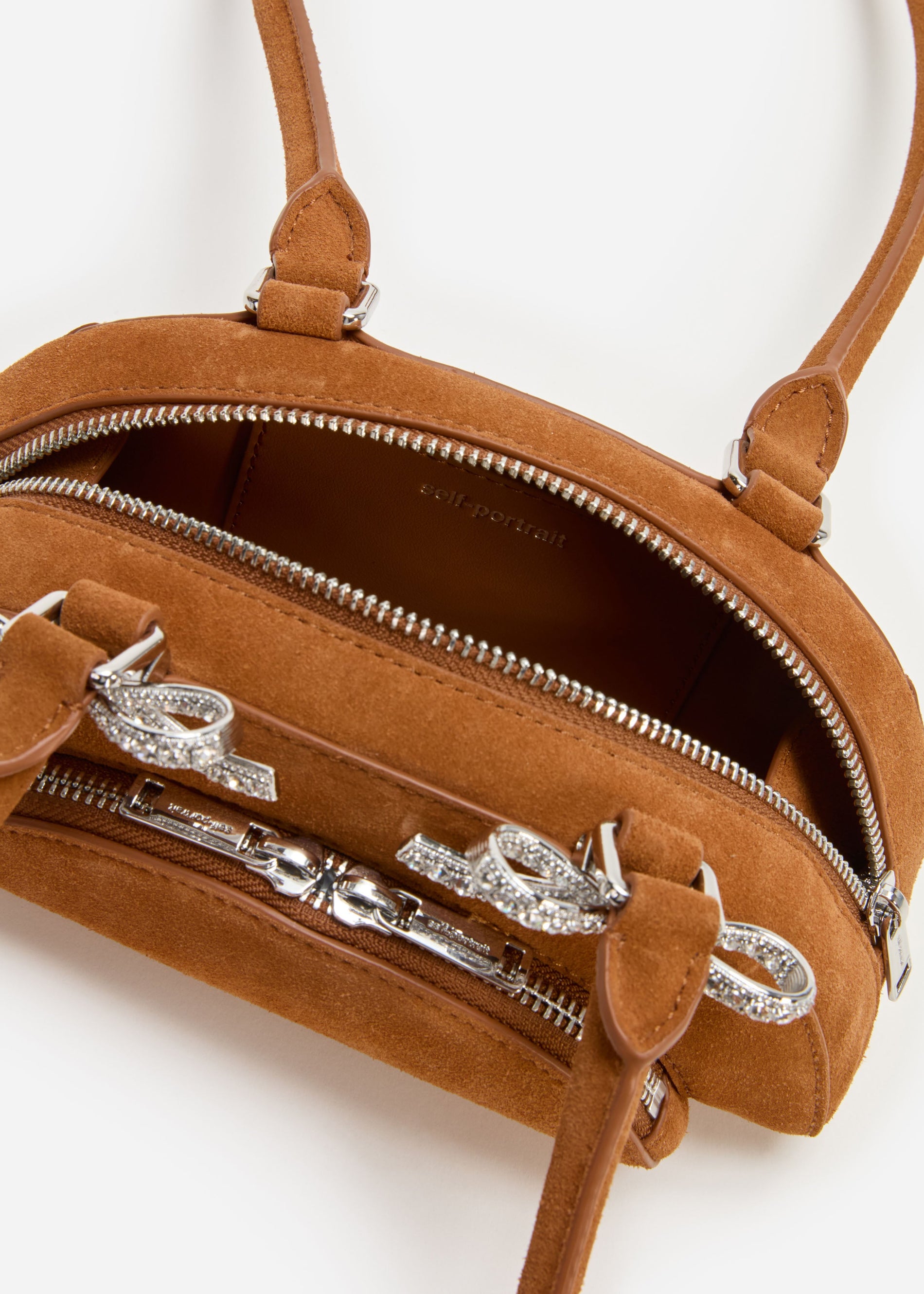 A photo of the Brown Suede Curved Mini Shoulder Bag