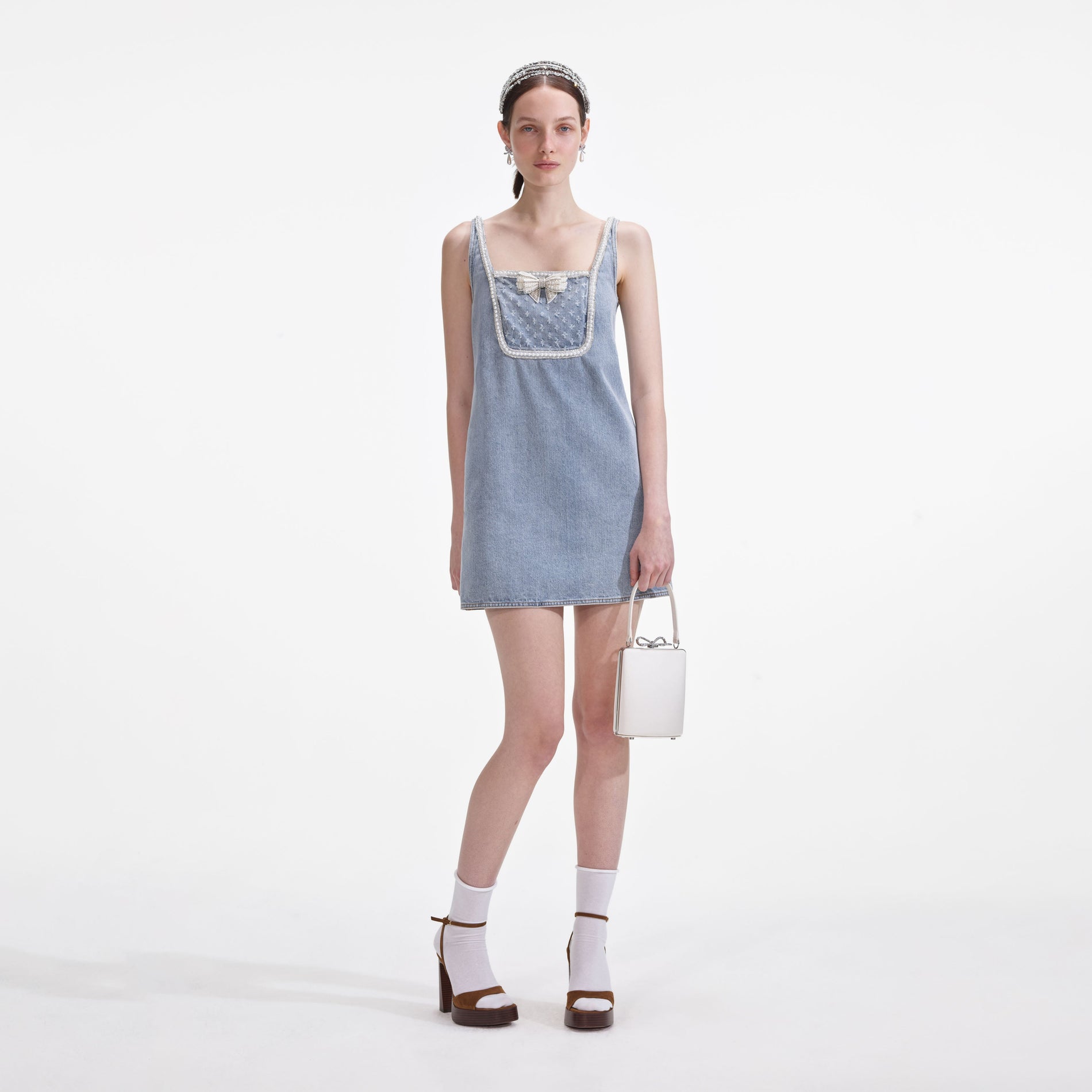 Front view of a woman wearing the Light Blue Denim Bow Mini Dress