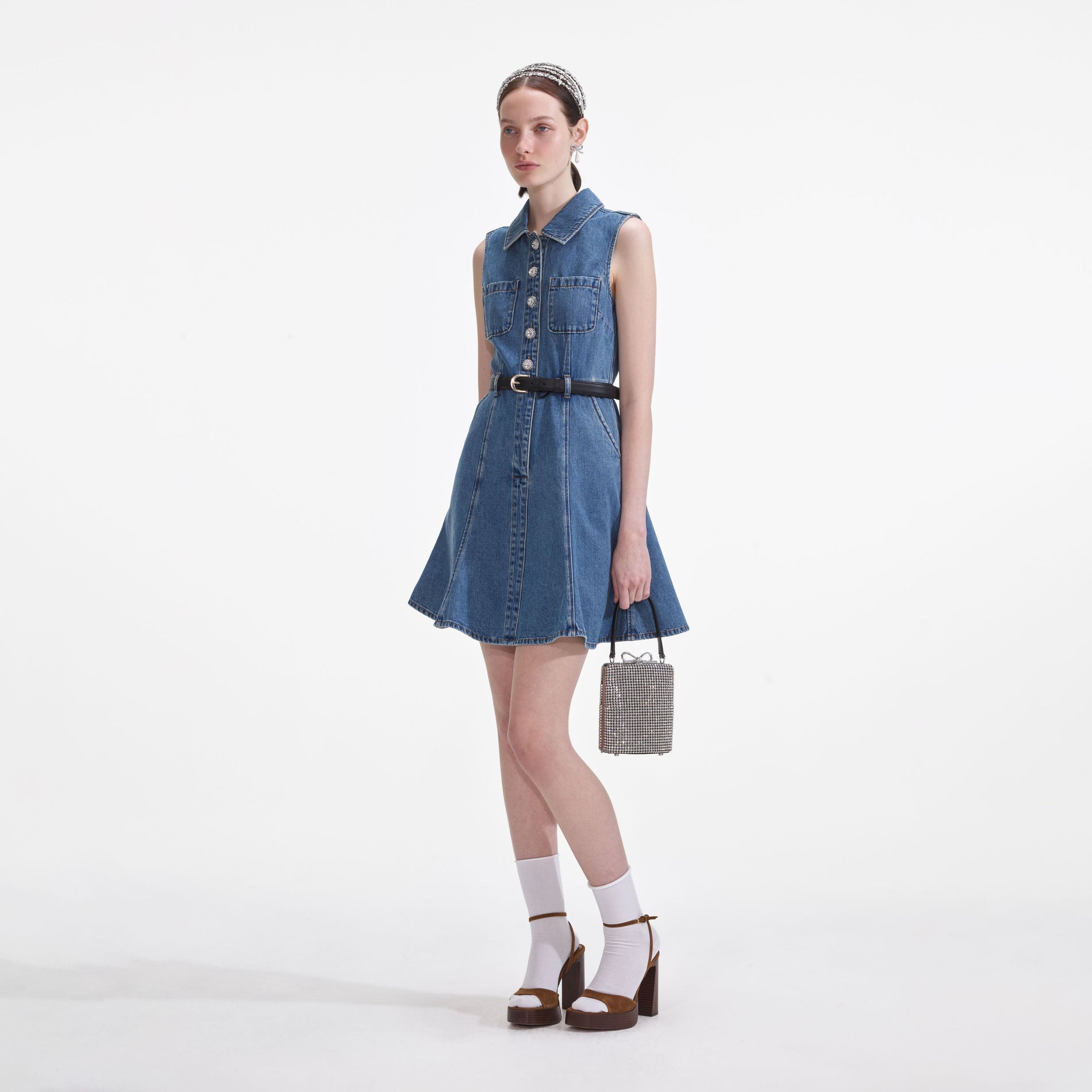 Side view of a woman wearing the Denim Sleeveless Pearl Mini Dress