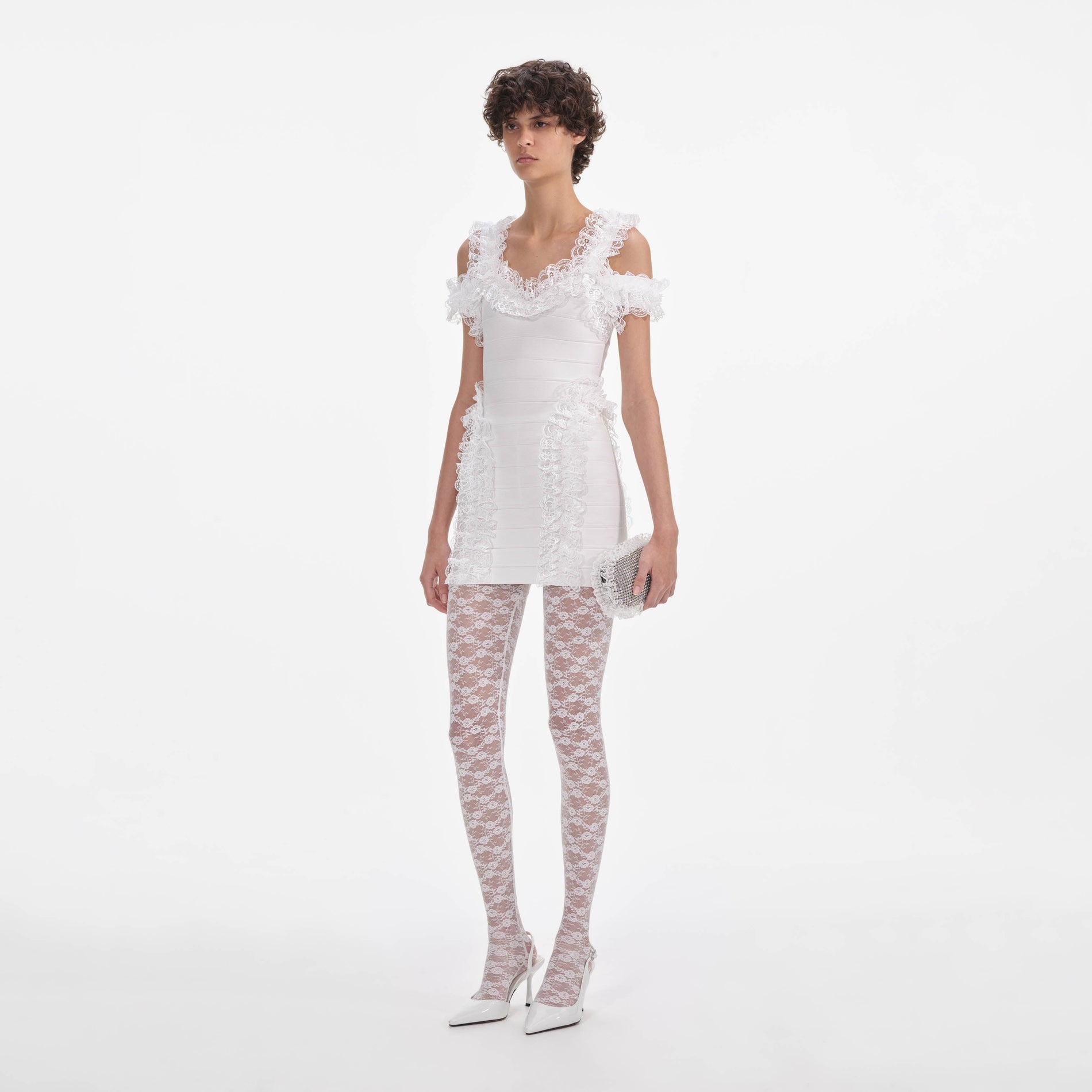 Side view of a woman wearing the White Knit Ruffle Mini Dress