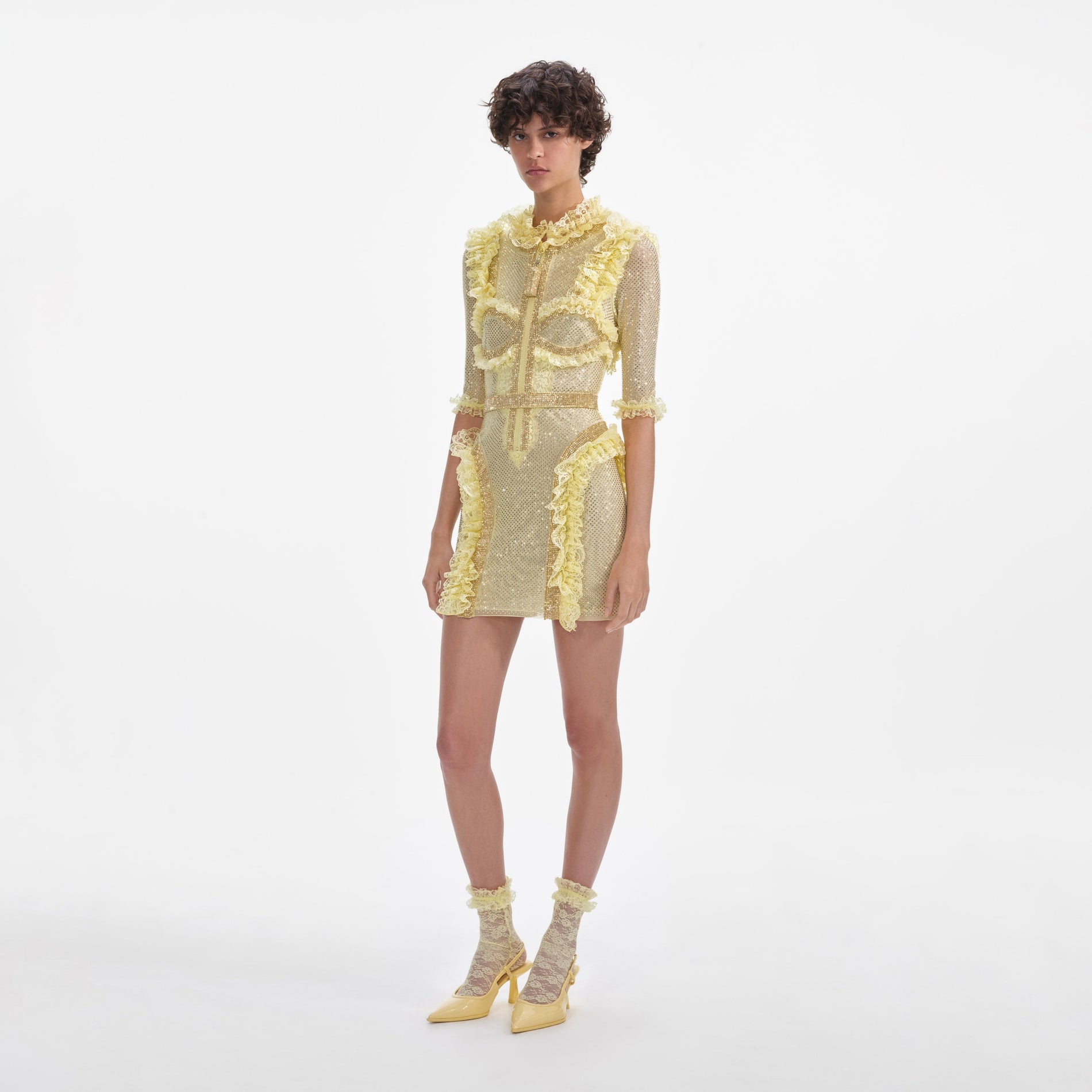 Side view of a woman wearing the Yellow Rhinestone Mesh Ruffle Mini Dress