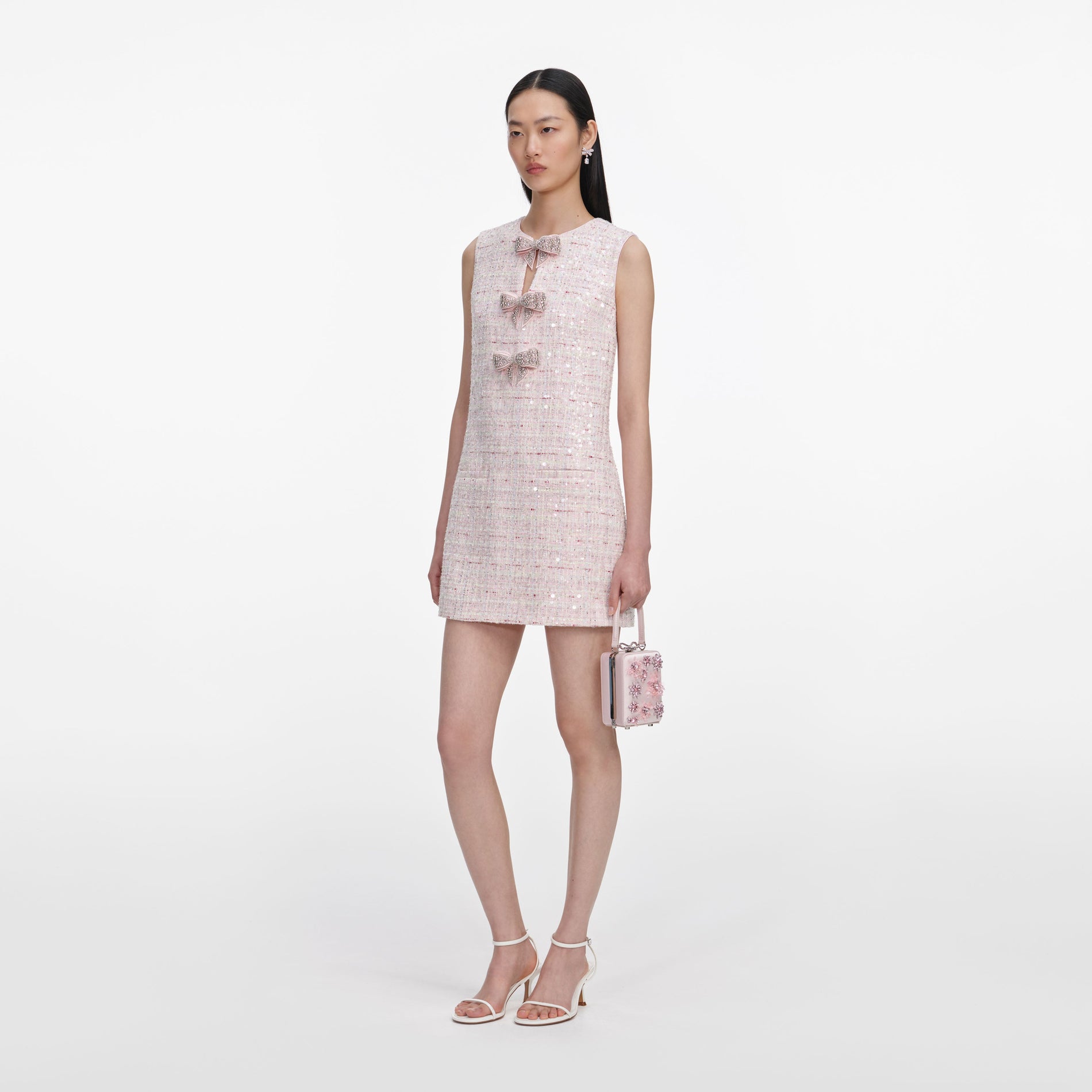 Side view of a woman wearing the Pink Sequin Boucle Bow Mini Dress