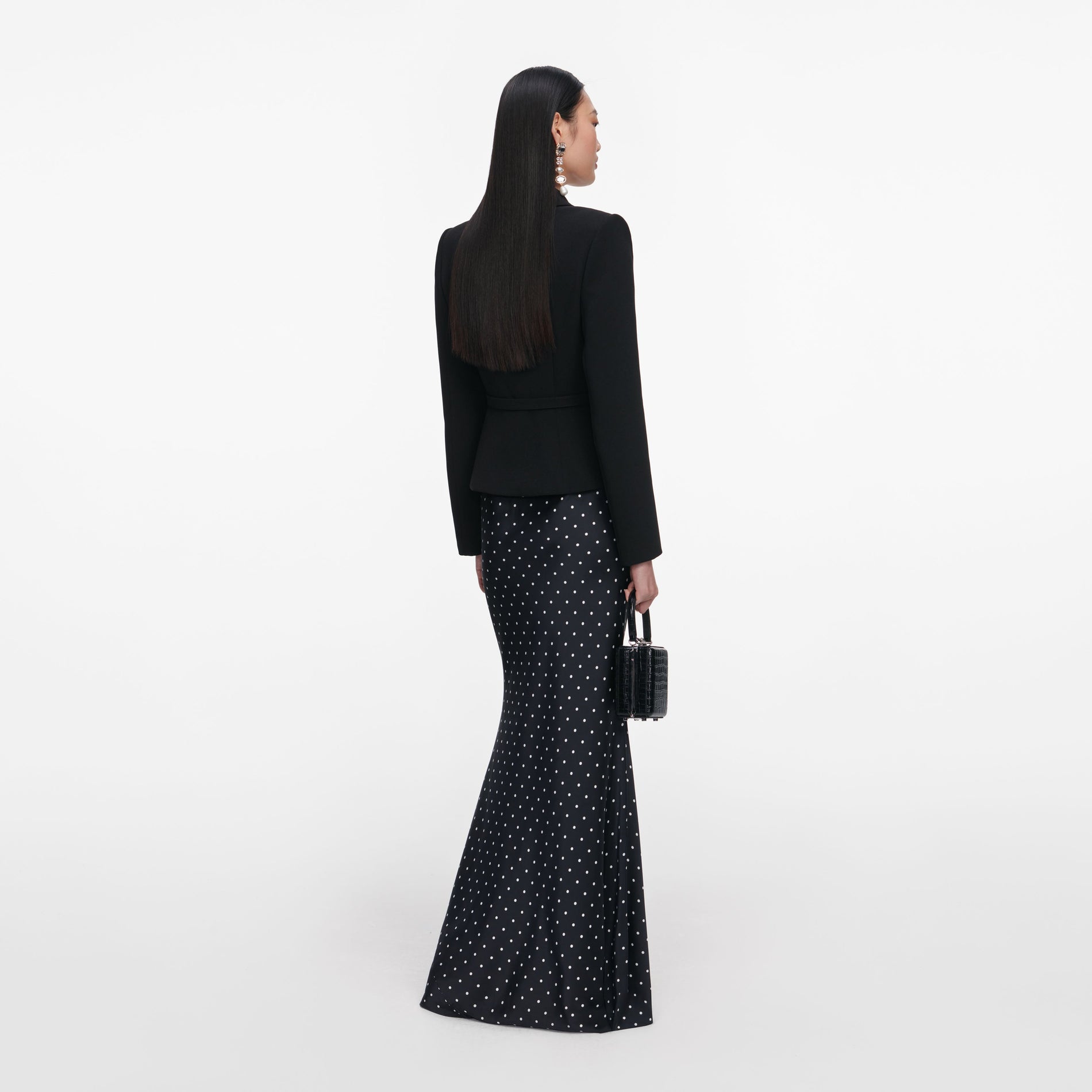 Back view of a woman wearing the Black Crepe Polka Dot Maxi Dress