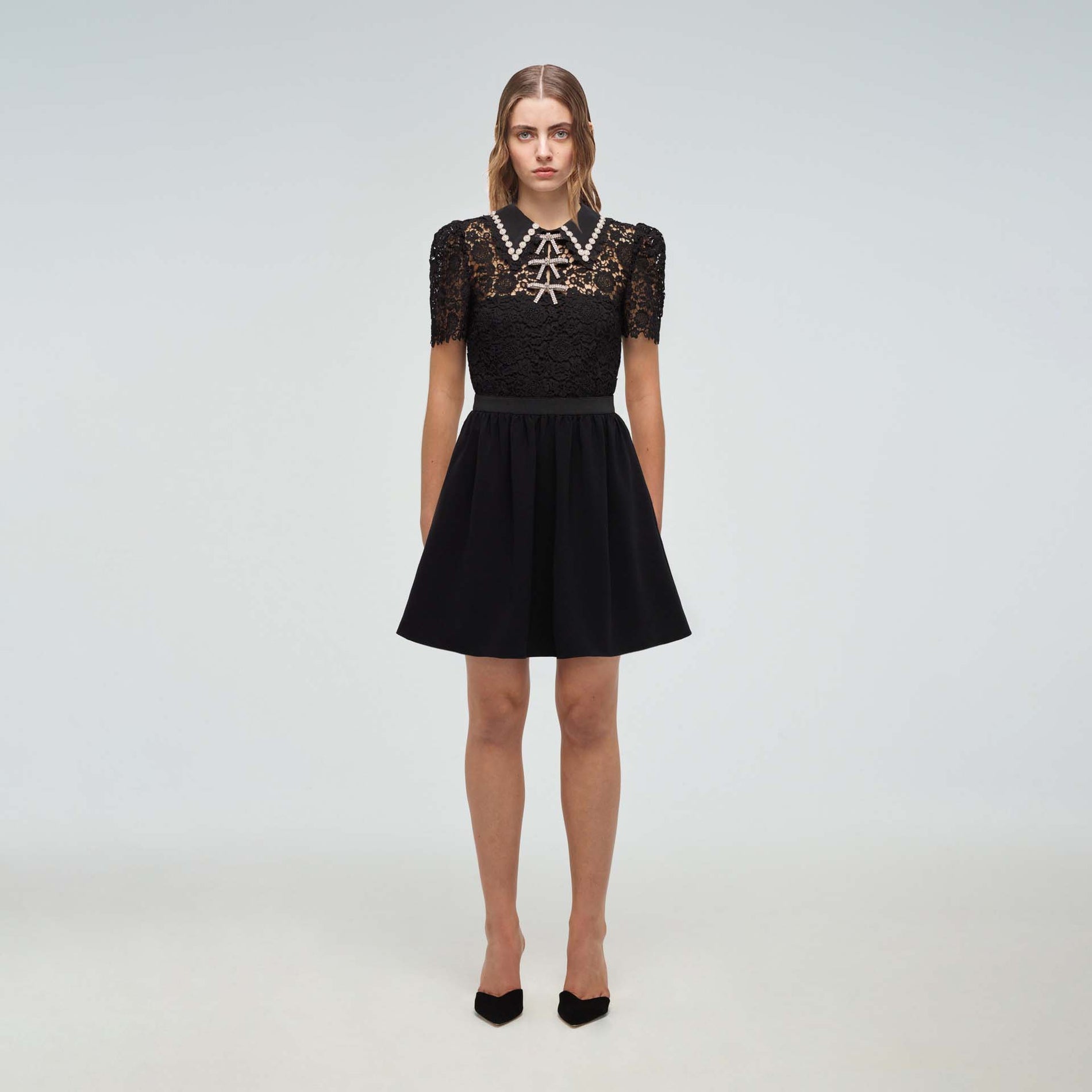 A woman wearing the Black Guipure Mini Dress