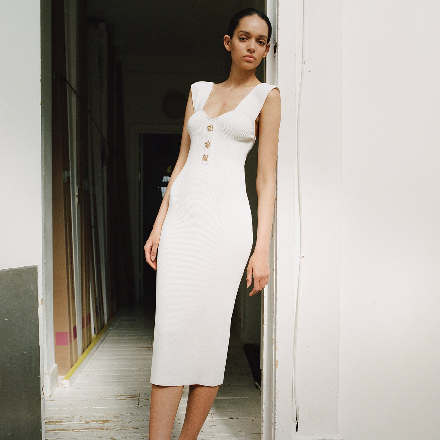 A woman wearing the White Off Shoulder Ribbed Knit Midi Dress