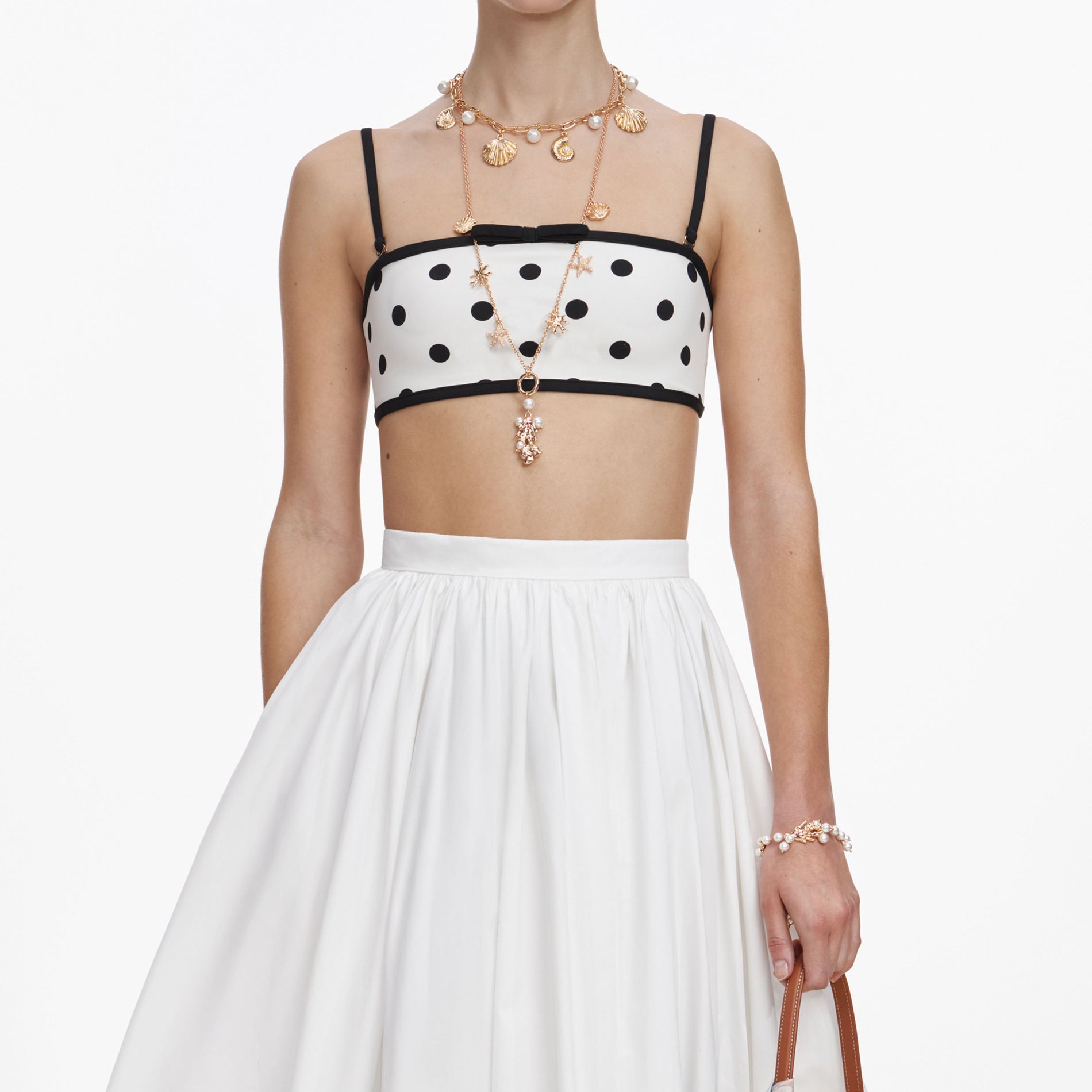 A close up of a woman wearing the White Polka Dot Bikini Top