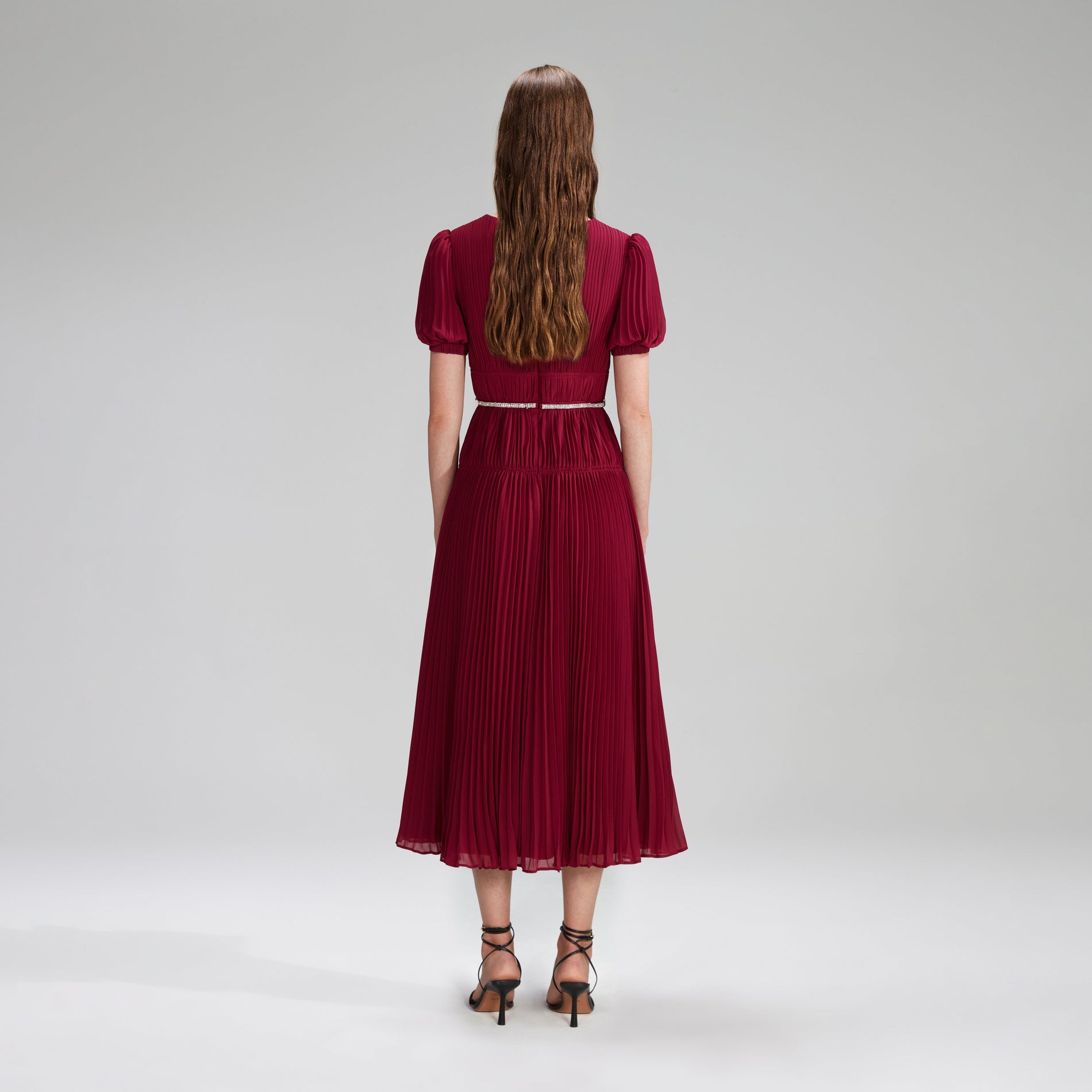 A woman wearing the Burgundy Chiffon Pleated Midi Dress