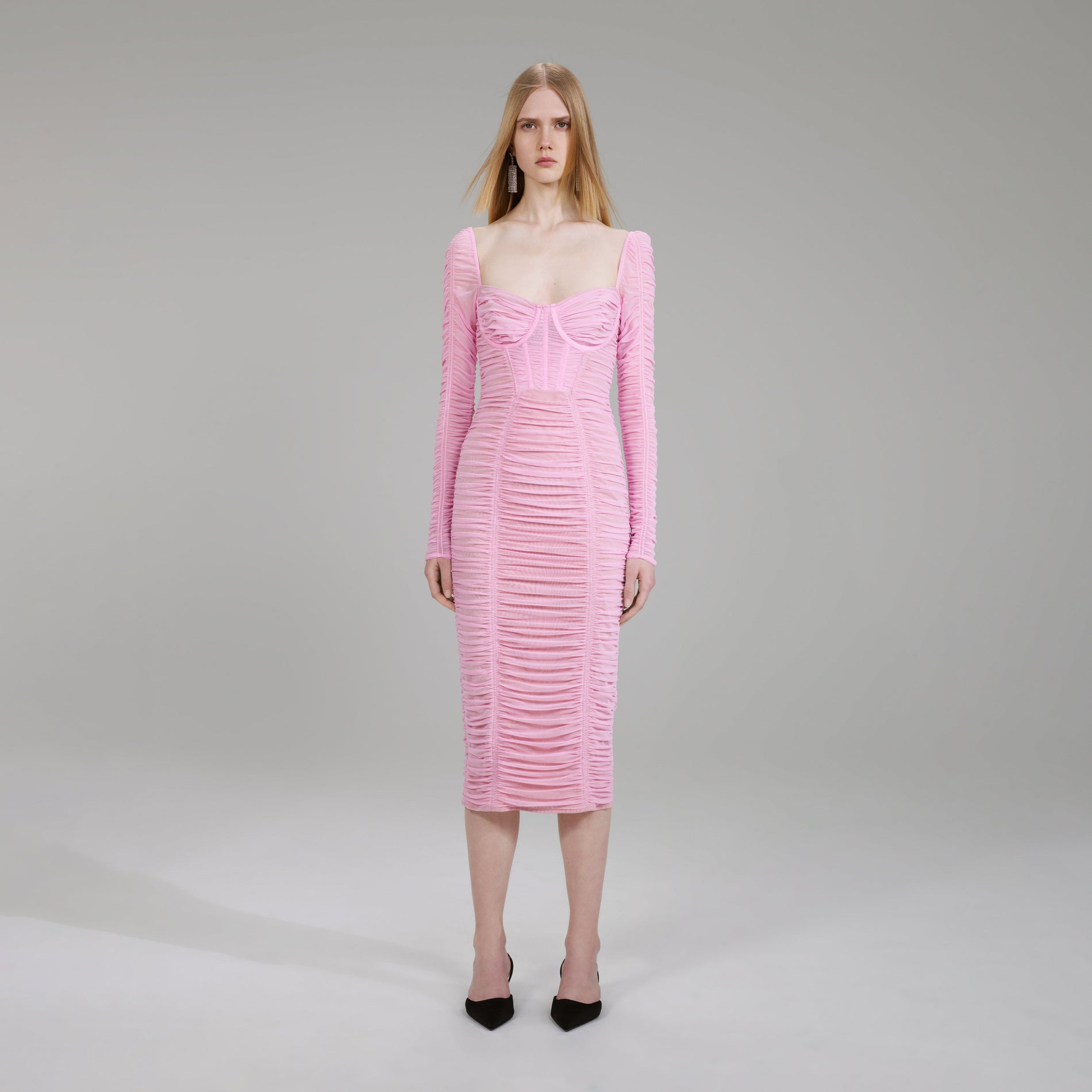 A woman wearing the Pink Power Mesh Long Sleeve Midi Dress