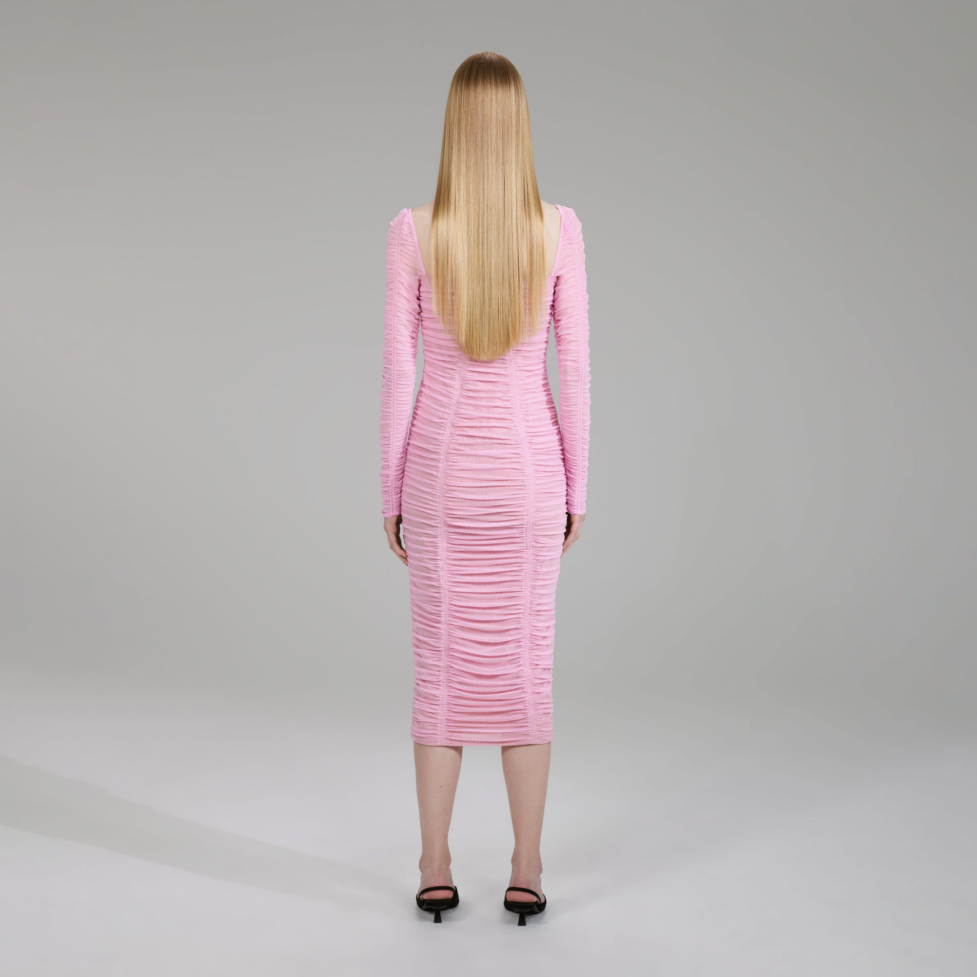 A woman wearing the Pink Power Mesh Long Sleeve Midi Dress