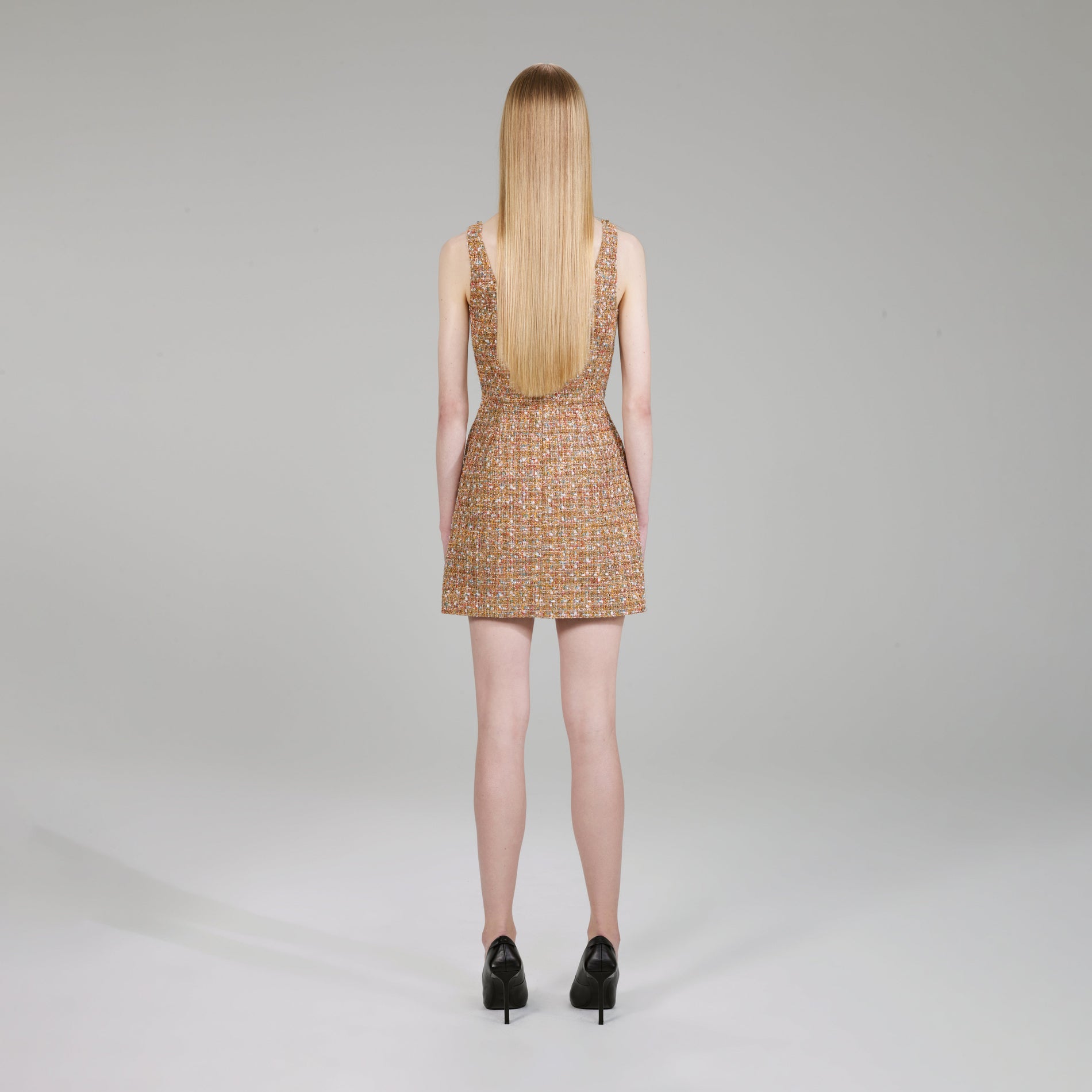 A woman wearing the Gold Tinsel Bouclé Mini Dress