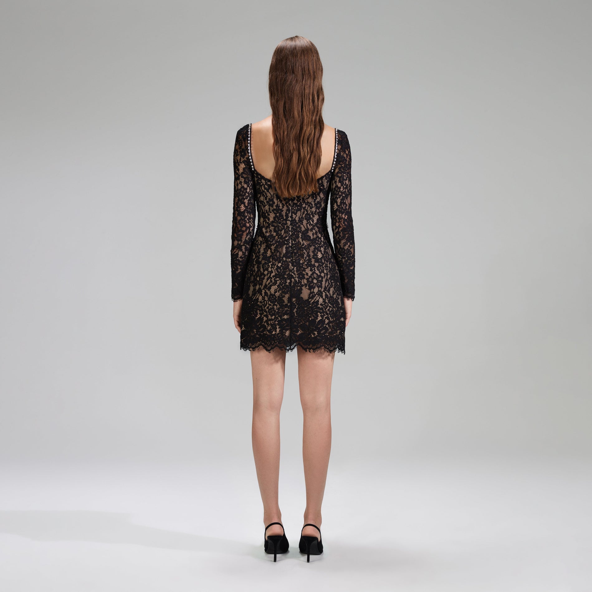 A woman wearing the Black Corded Lace Mini Dress