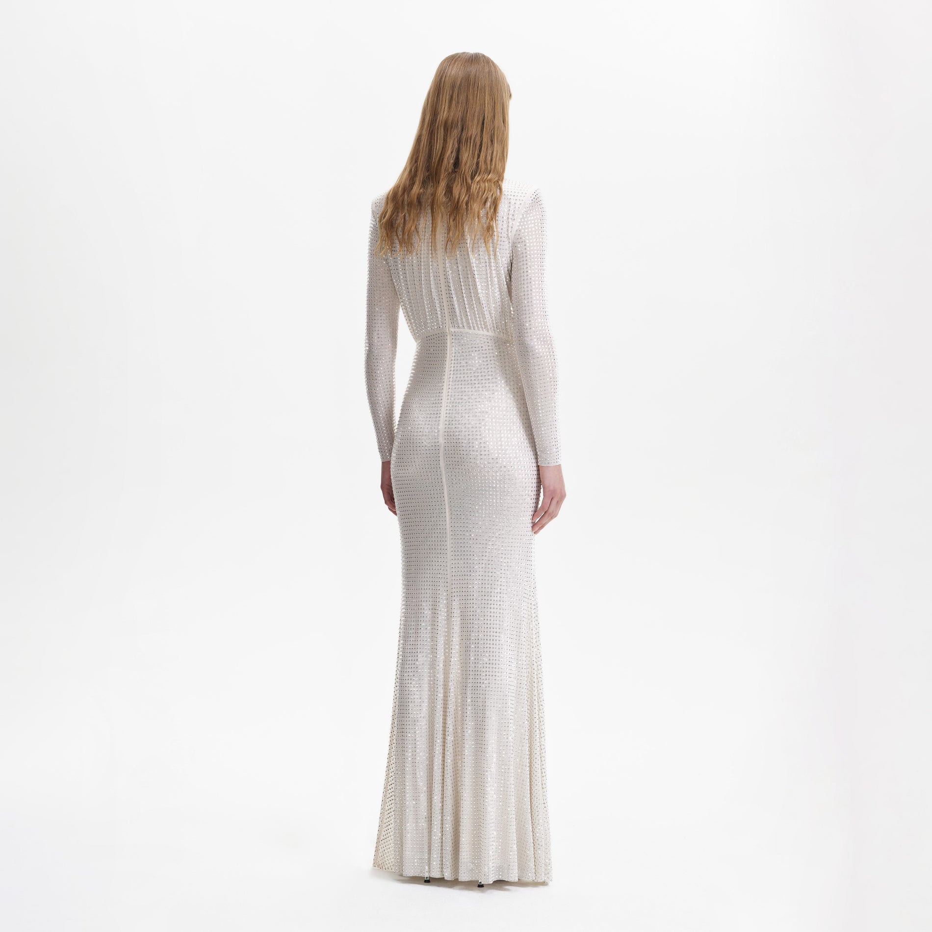 A woman wearing the Cream Rhinestone Mesh Long Sleeve Maxi Dress