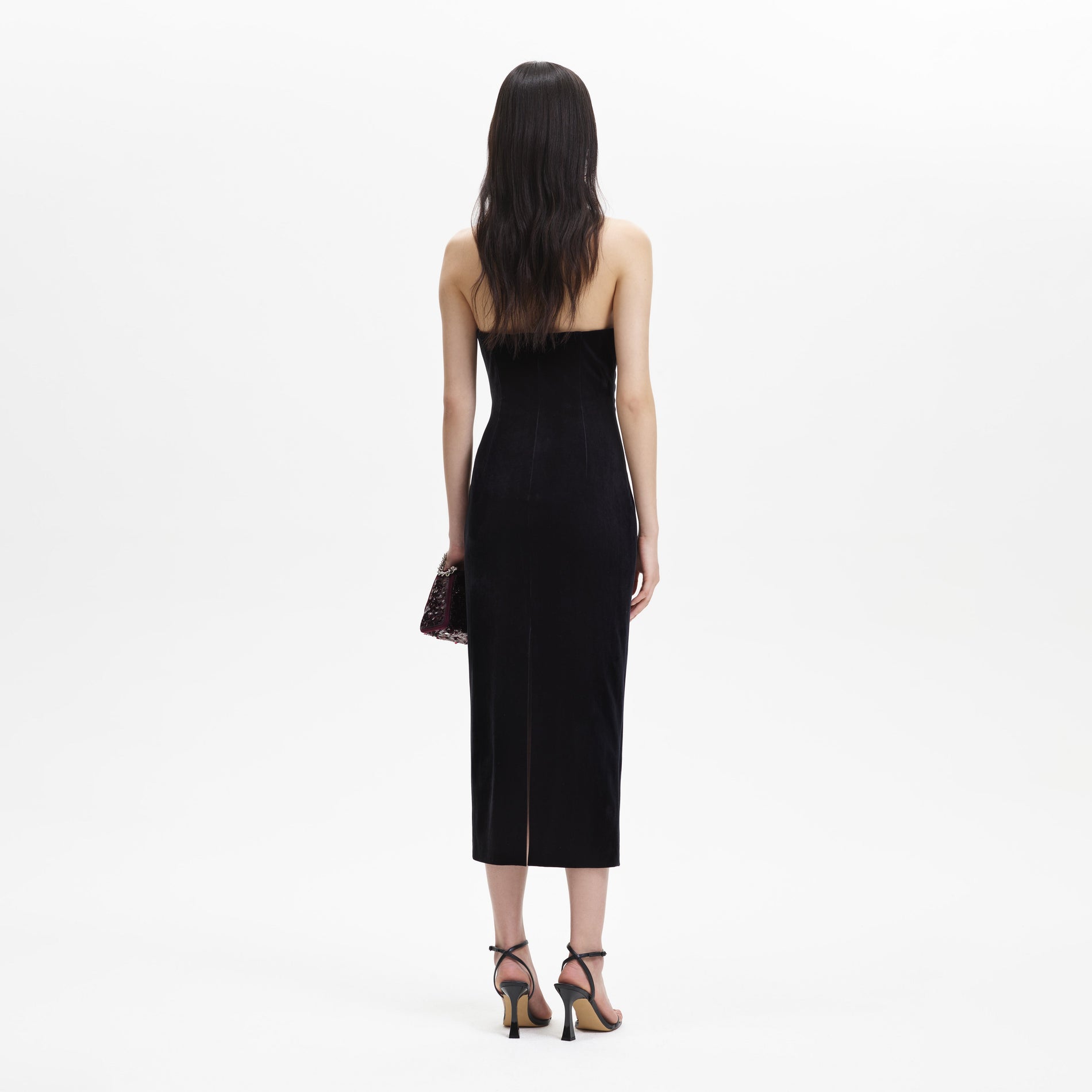 A woman wearing the Black Velvet Strapless Midi Dress