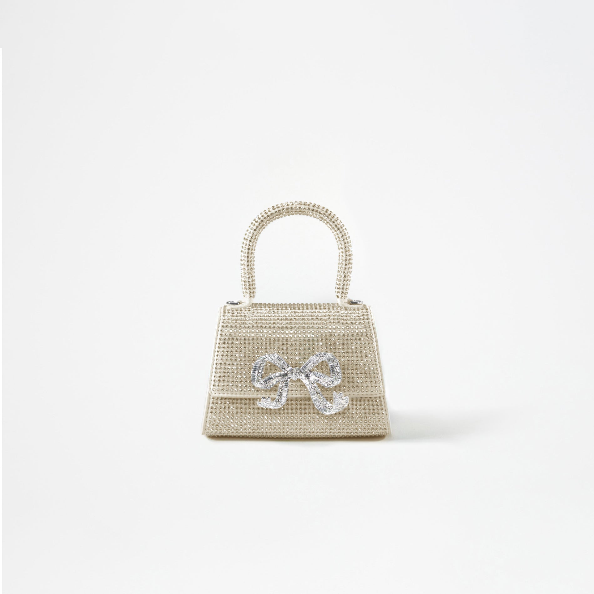 A woman wearing the Cream Rhinestone Bow Micro Bag