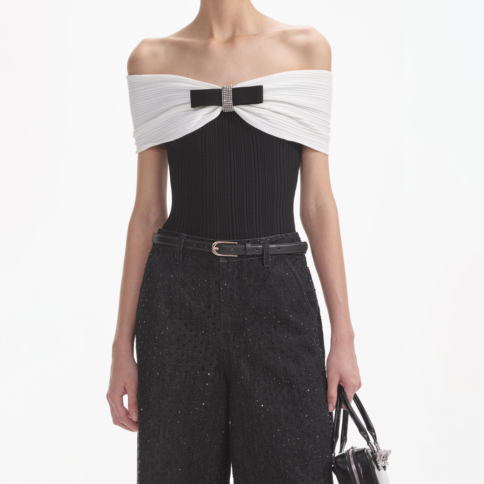 A close up of a woman wearing the Black Knit Bow Top