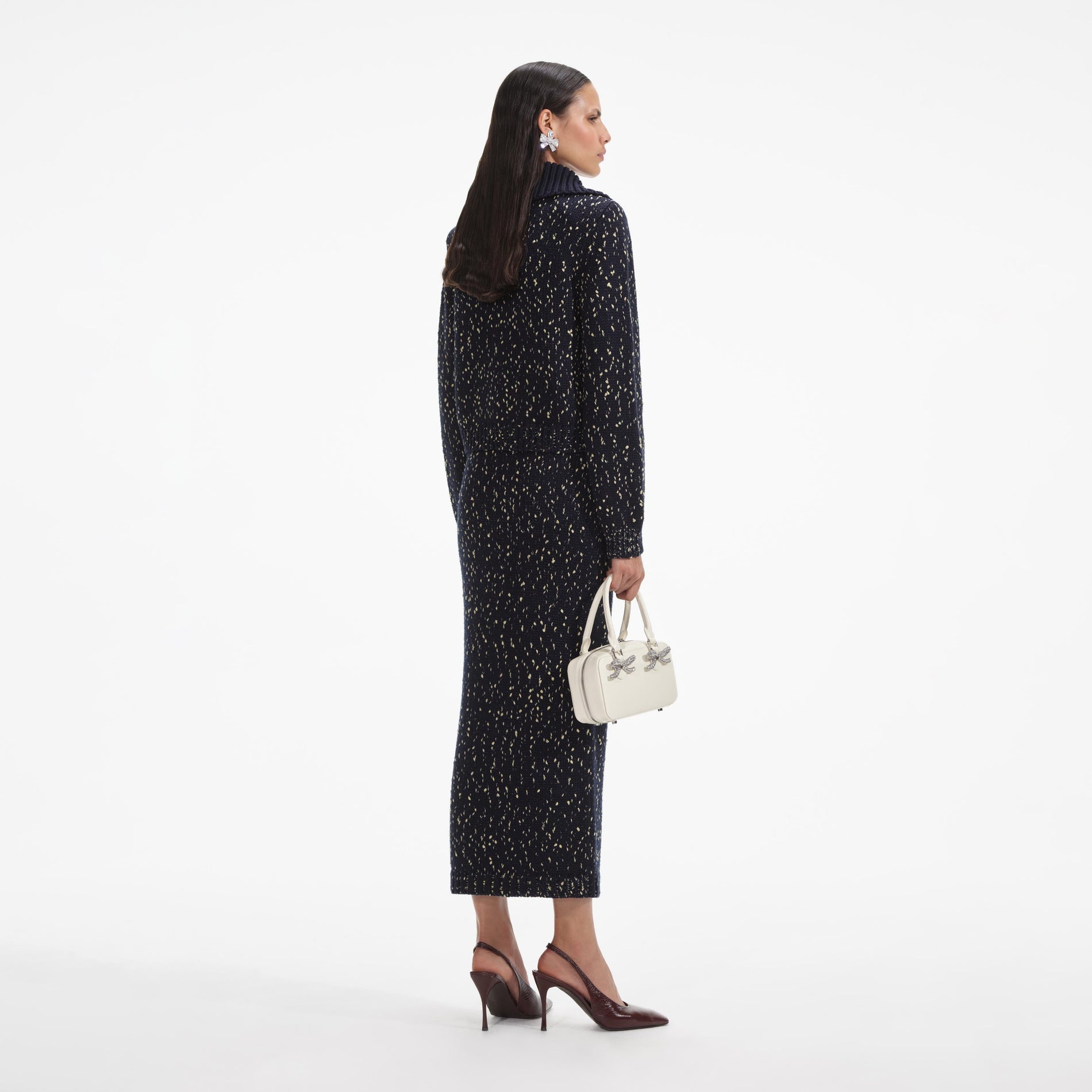 Back view of a woman wearing the White Navy Metallic Merino Knit Midi Skirt