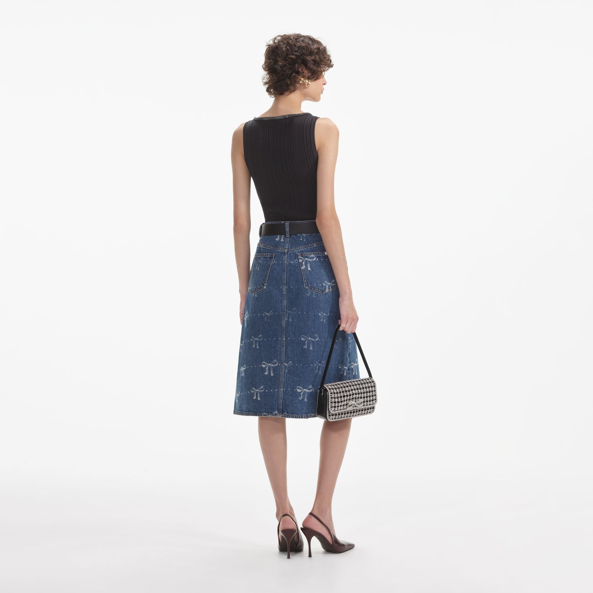 Back view of a woman wearing the White Bow Print Denim Midi Skirt