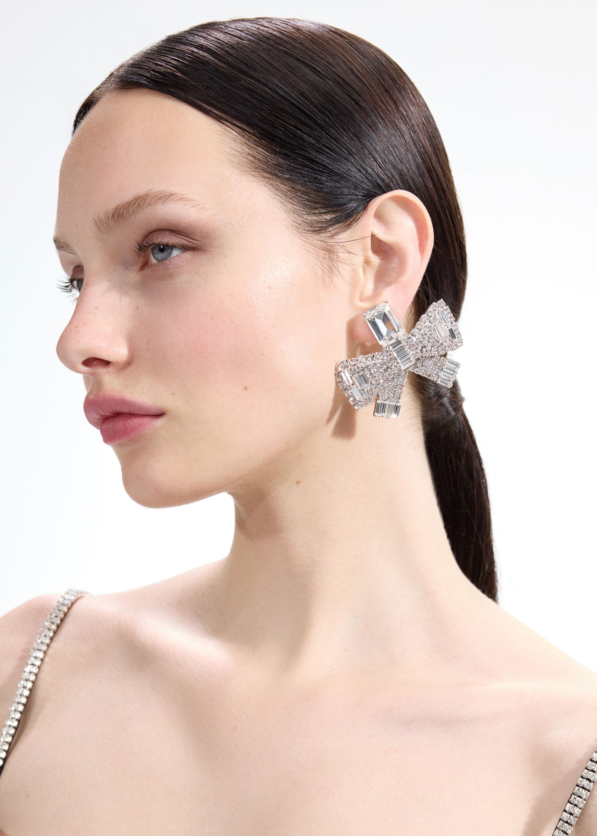 Back view of a woman wearing the White Large Crystal Bow Earrings
