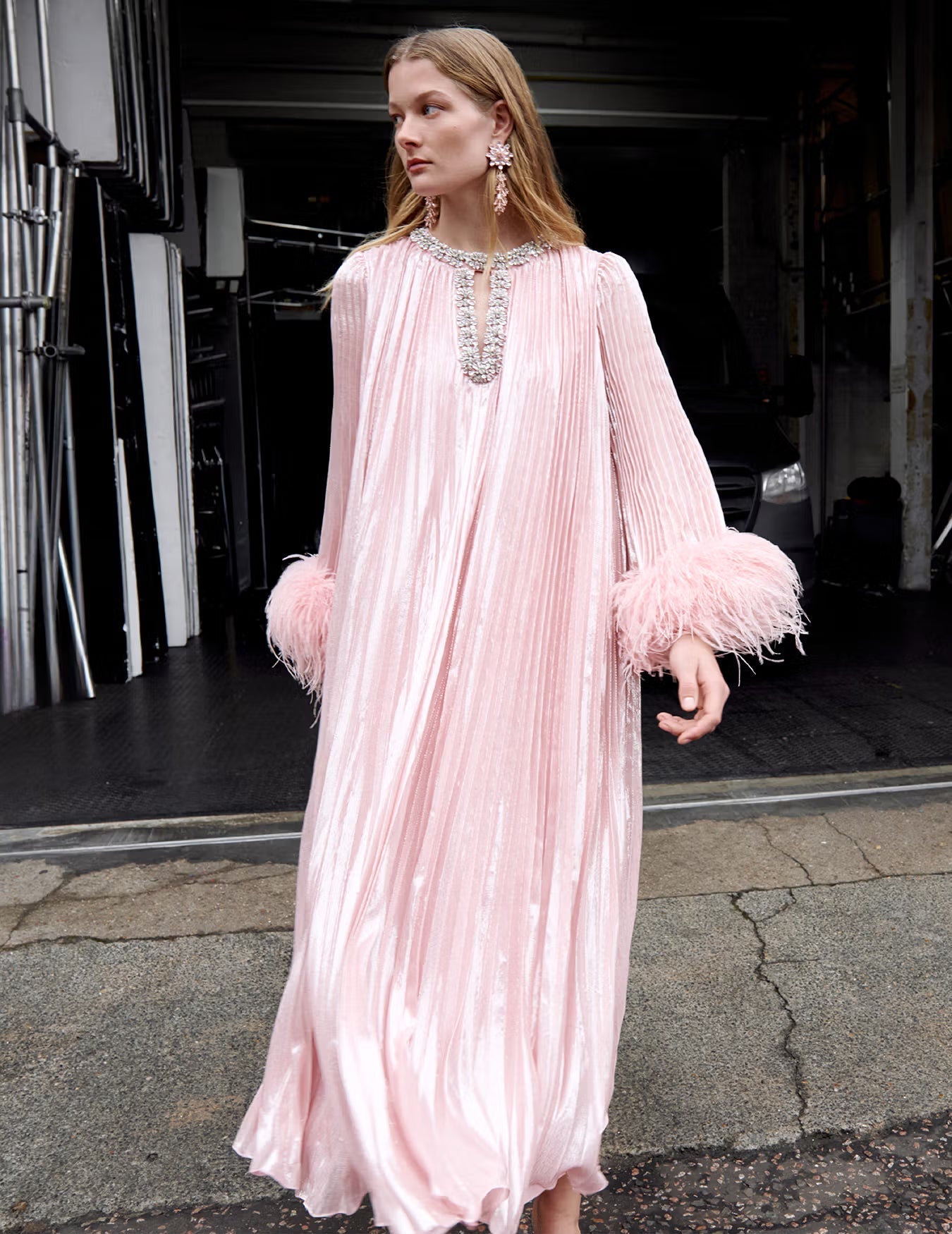 A lifestyle image of a woman wearing the Pink Metallic Chiffon Feather Midi Dress