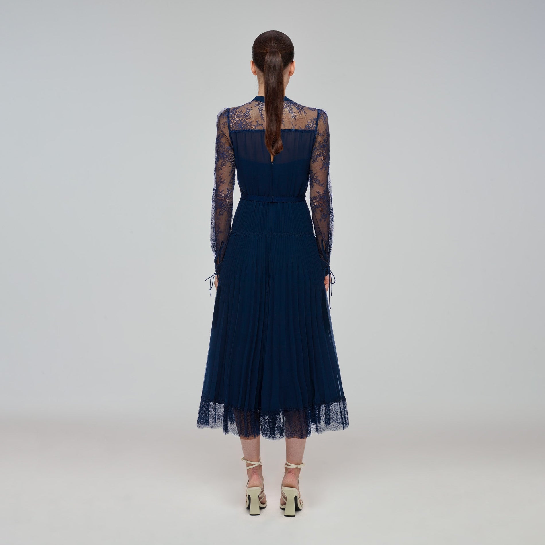 A woman wearing the Navy Lace Trim Midi Dress