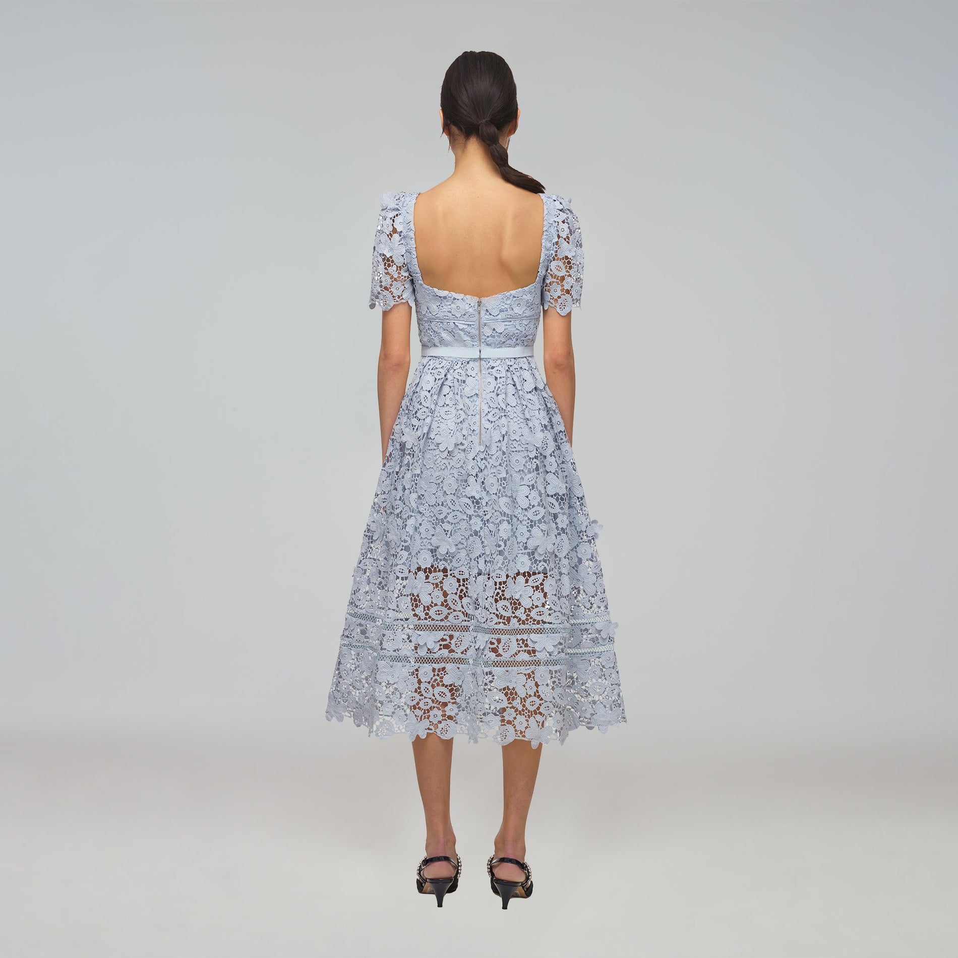 A woman wearing the Powder Blue Guipure Lace Midi Dress