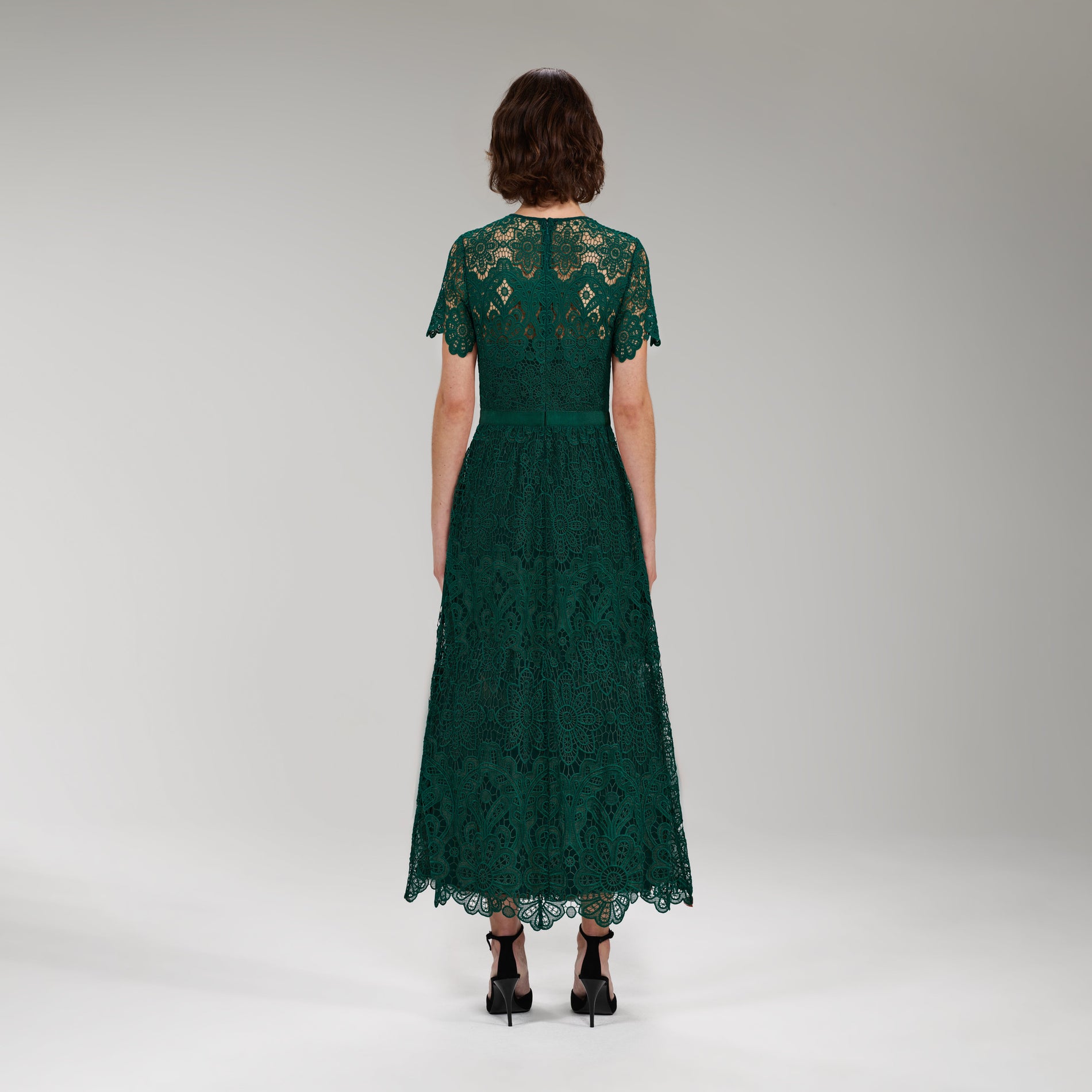 A woman wearing the Dark Green Floral Guipure Midi Dress