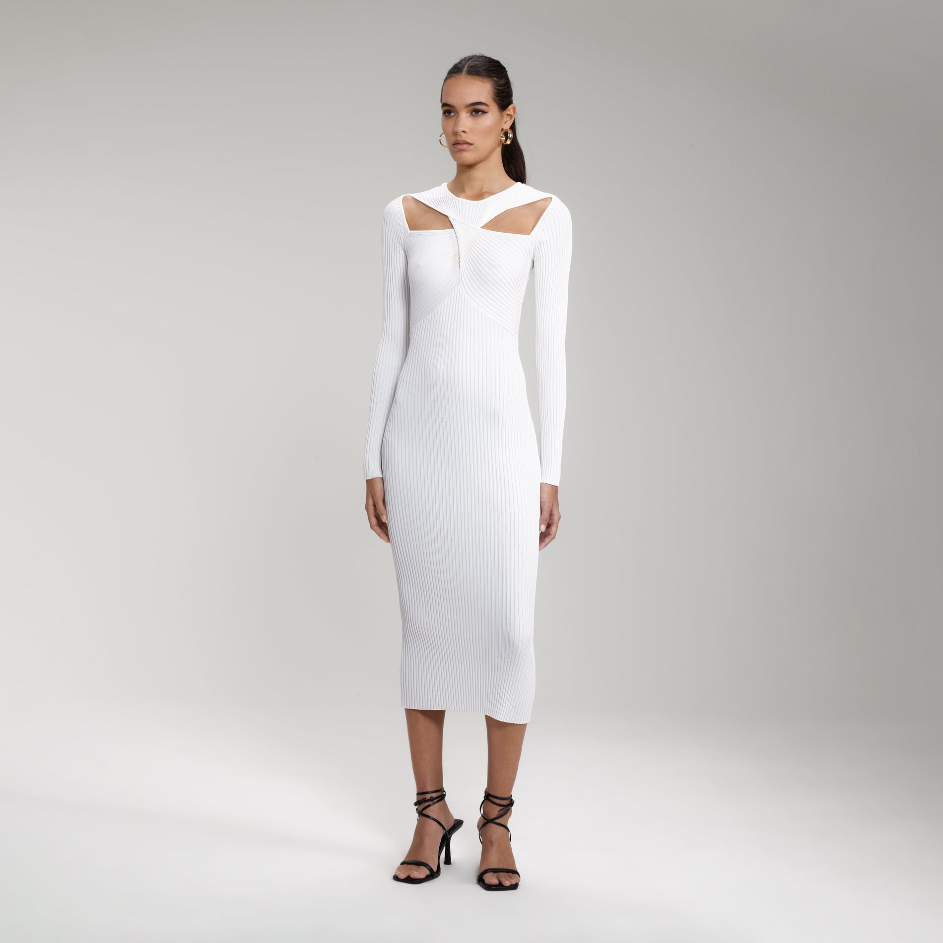 A woman wearing the White Ribbed Knit Cut Out Midi Dress