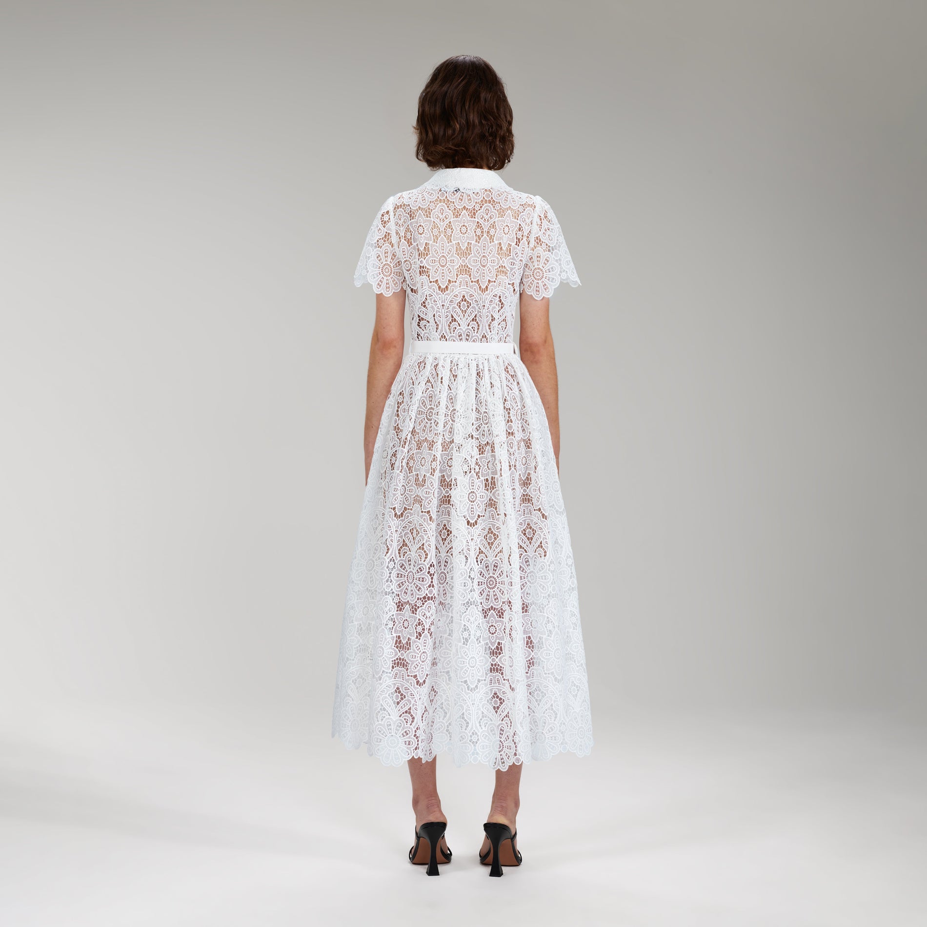 A woman wearing the White Floral Guipure Lace Midi Dress