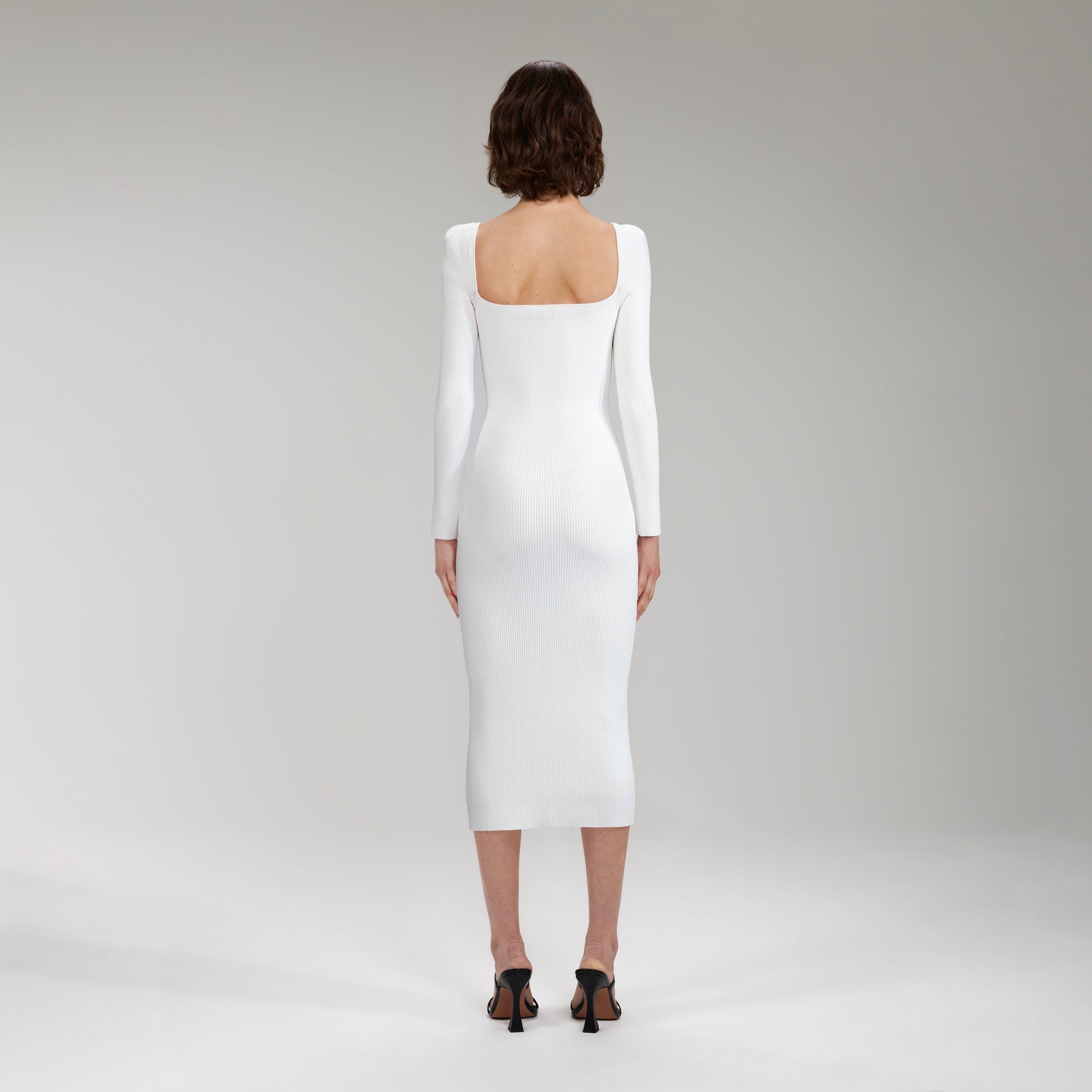 A woman wearing the White Long Sleeve Ribbed Knit Midi Dress