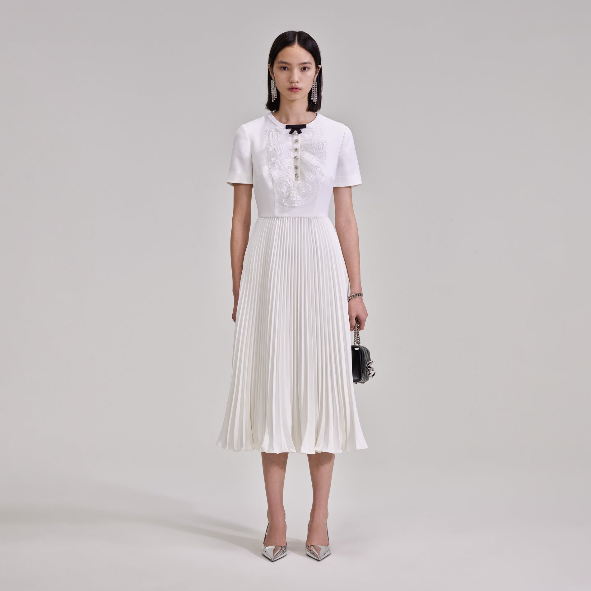 A woman wearing the White Lace Bib Midi Dress