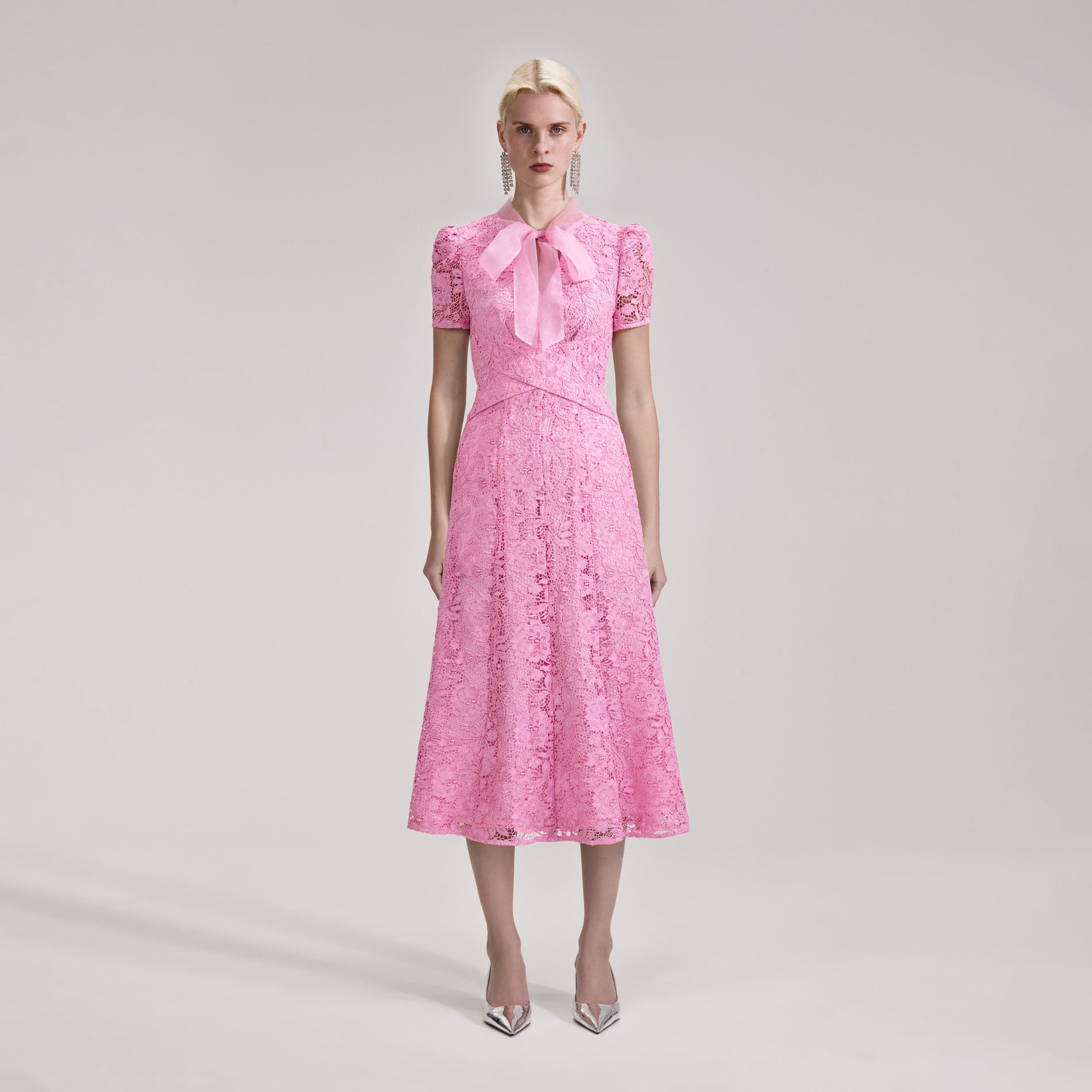 A woman wearing the Pink Cord Lace Crossover Midi Dress