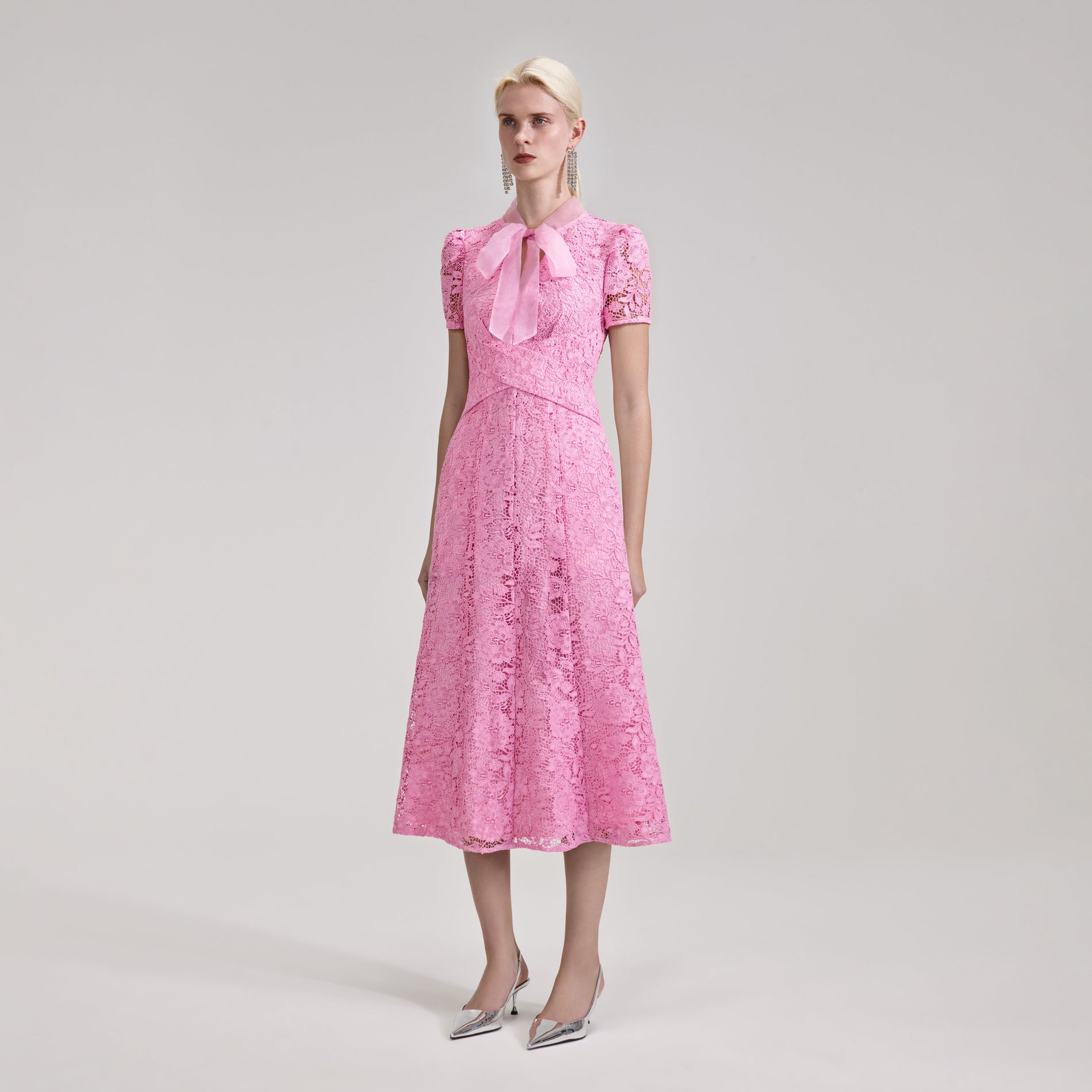 A woman wearing the Pink Cord Lace Crossover Midi Dress